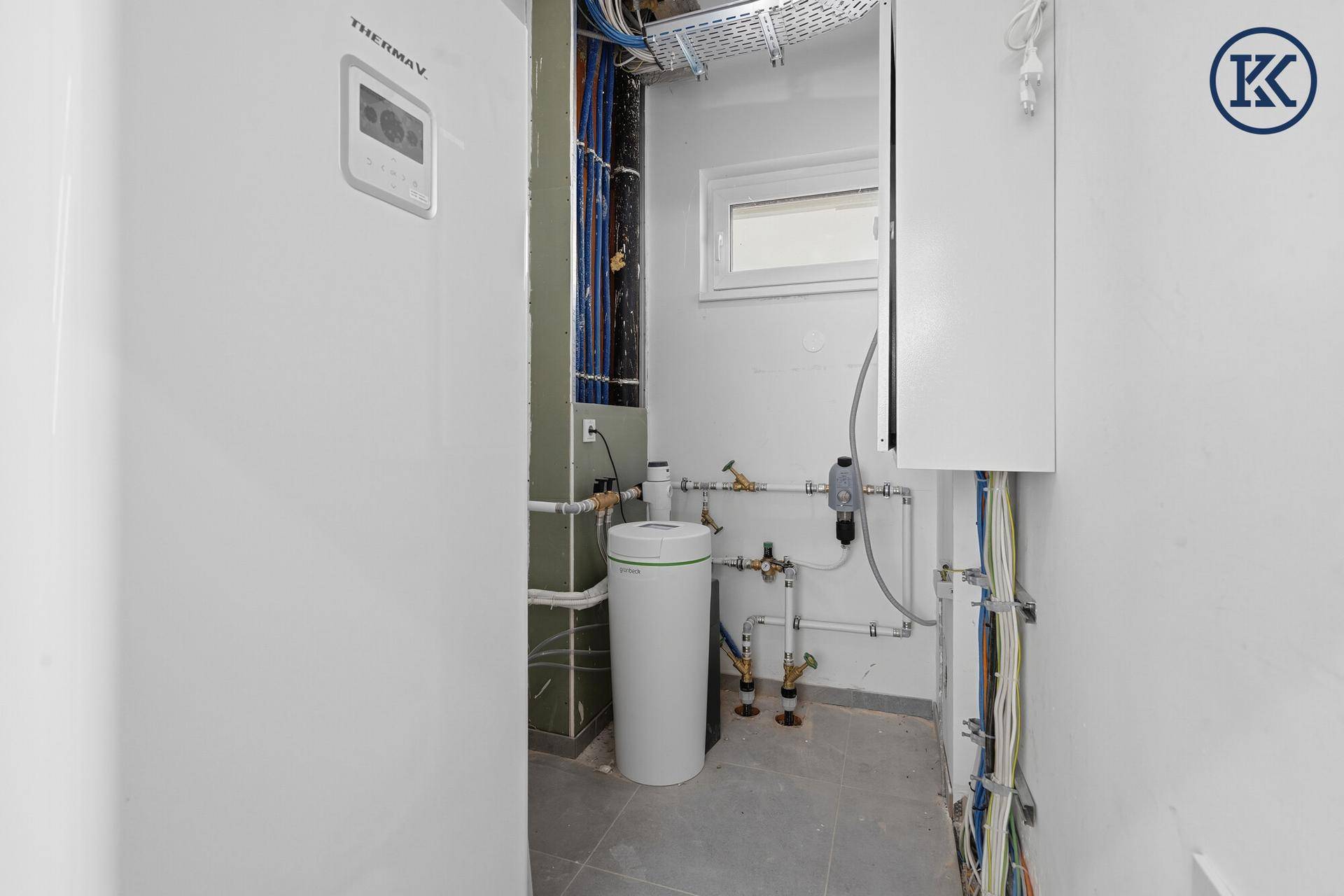 Technikraum mit moderner Wärmepumpe und Wasseraufbereitungssystem, bereit für den Erstbezug.