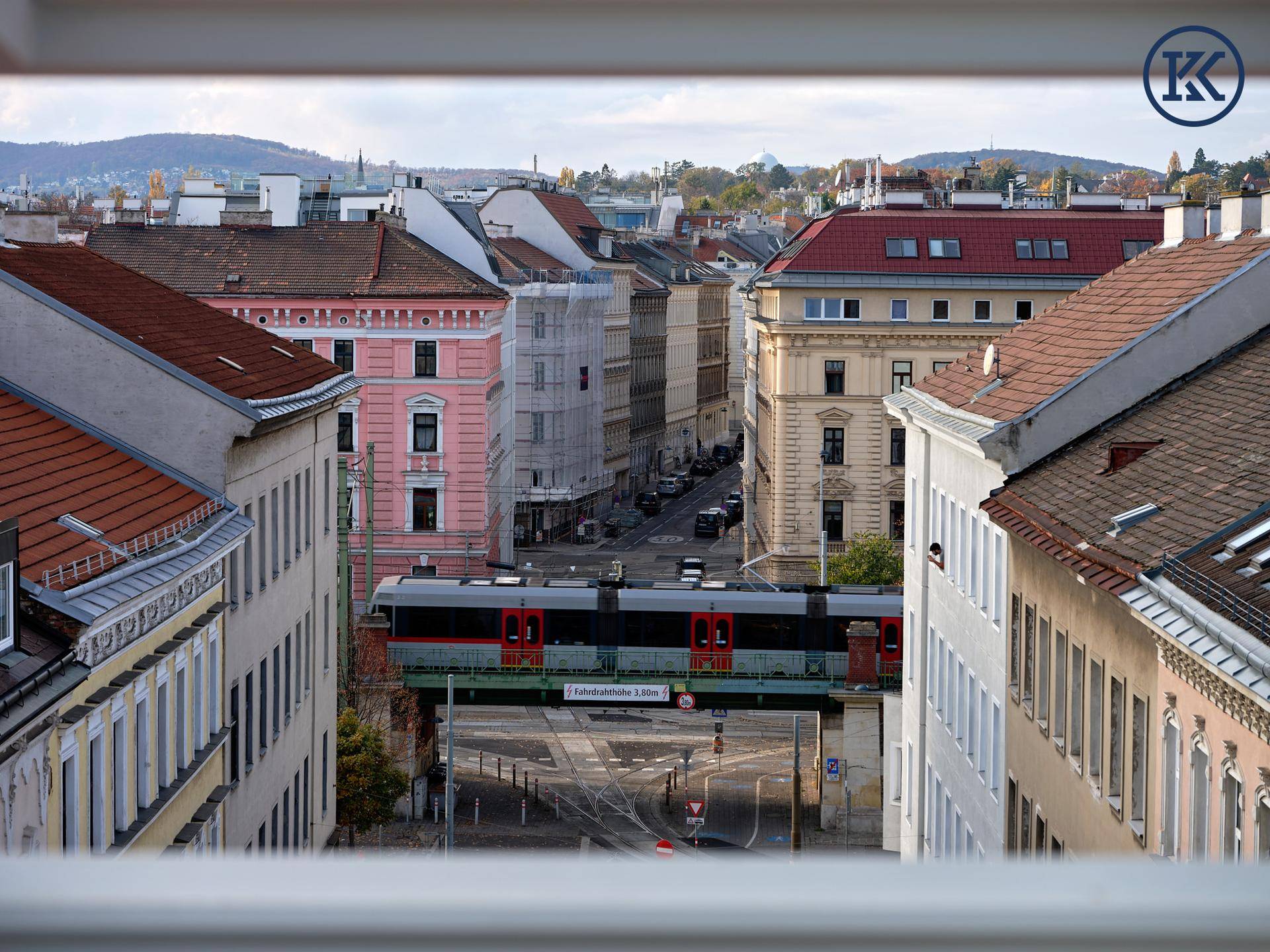 Blick auf eine belebte Stadtstraße mit einer Hochbahn, umgeben von historischen Gebäuden.