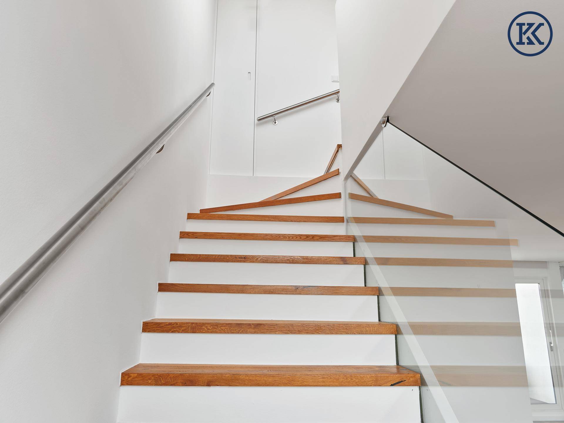 Elegante Holztreppe mit weiß lackierten Setzstufen und Edelstahlhandlauf.