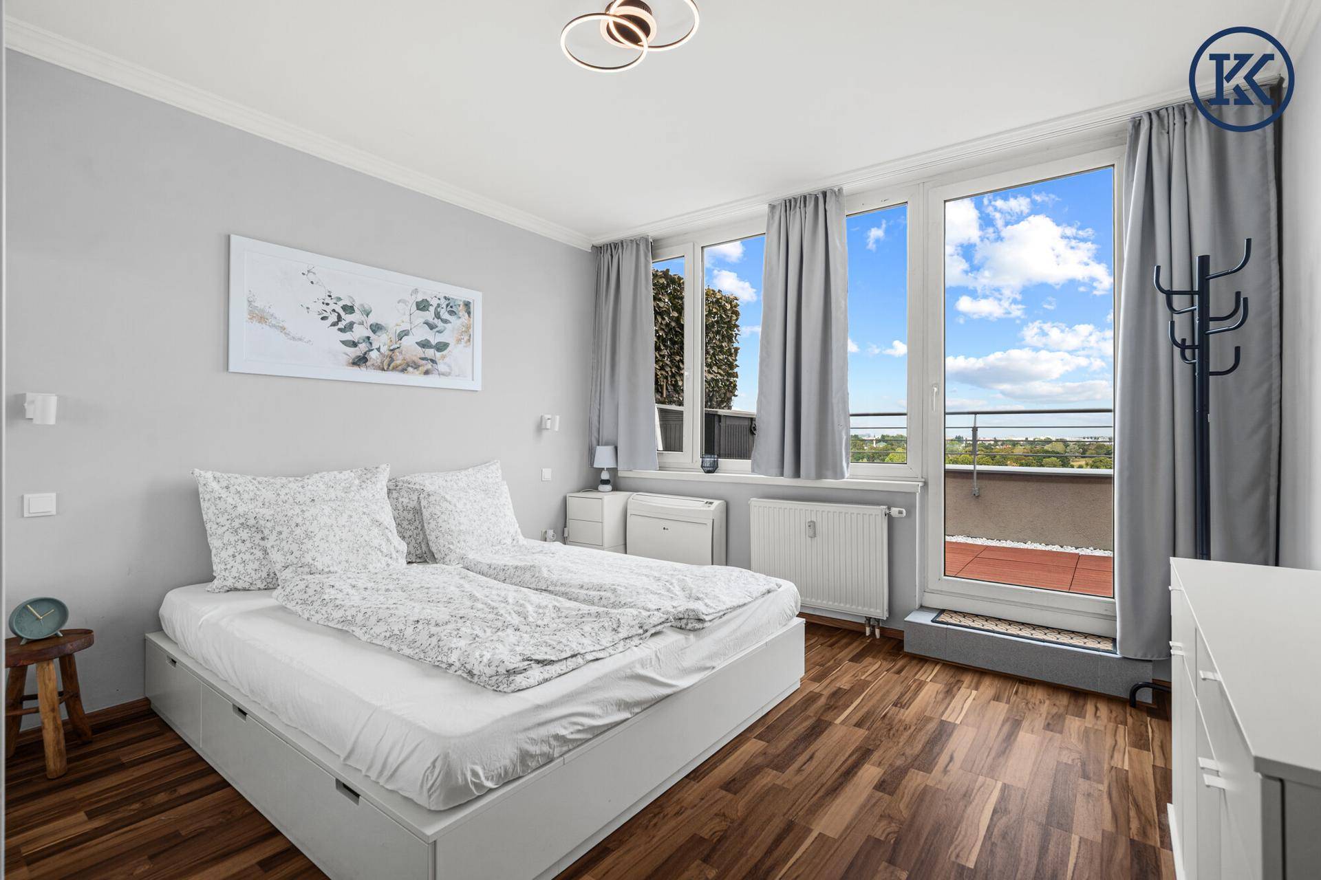 Helles Schlafzimmer mit Doppelbett, Holzboden und direktem Zugang zur Terrasse.