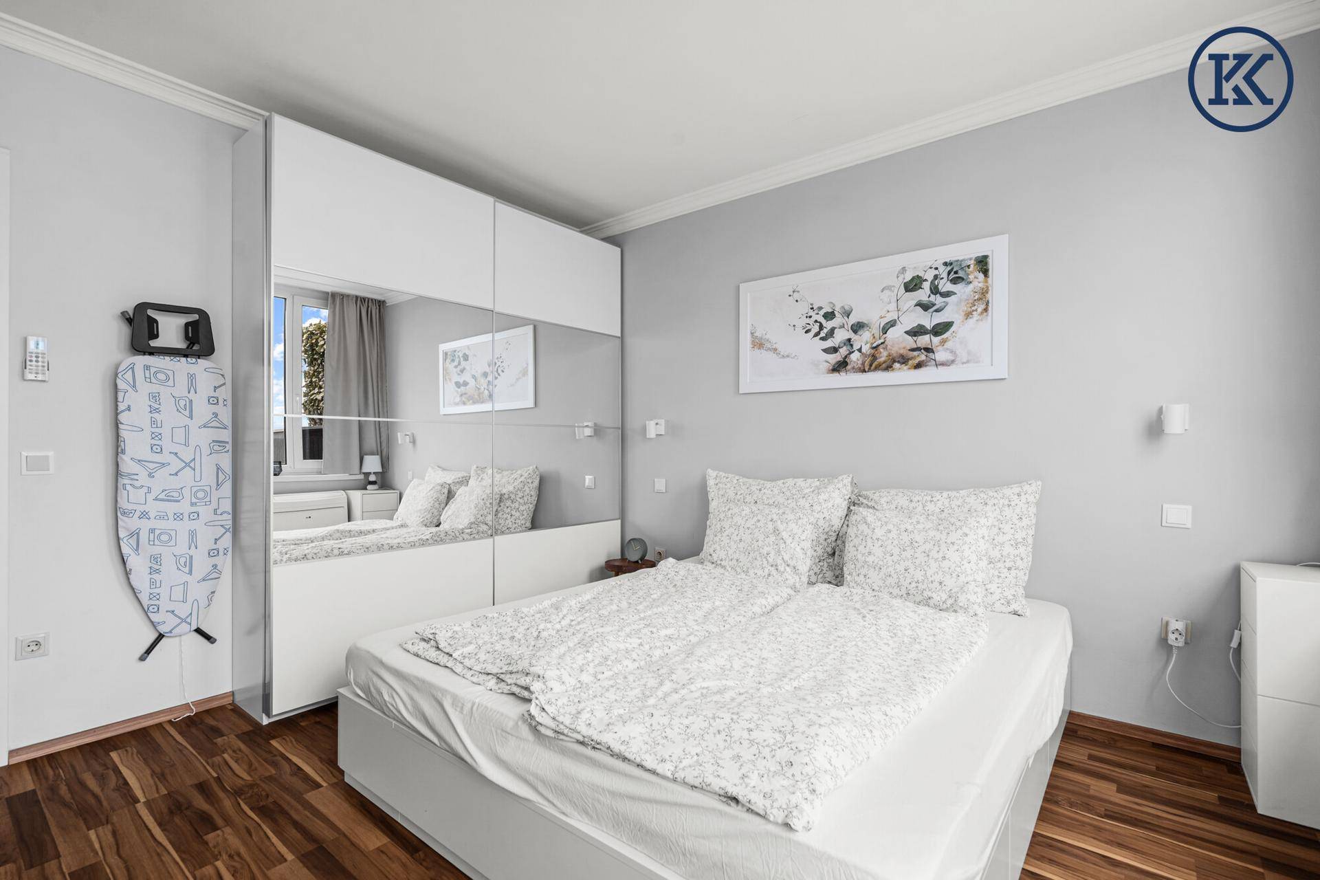 Gemütliches Schlafzimmer mit großem Bett, Spiegelschränken und Holzboden.
