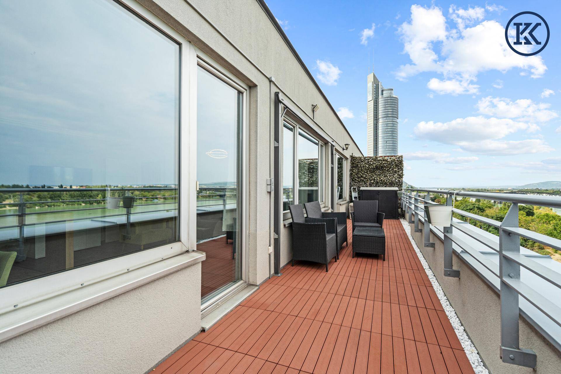 Weitläufige Dachterrasse mit Stadtblick und modernen Hochhäusern im Hintergrund.