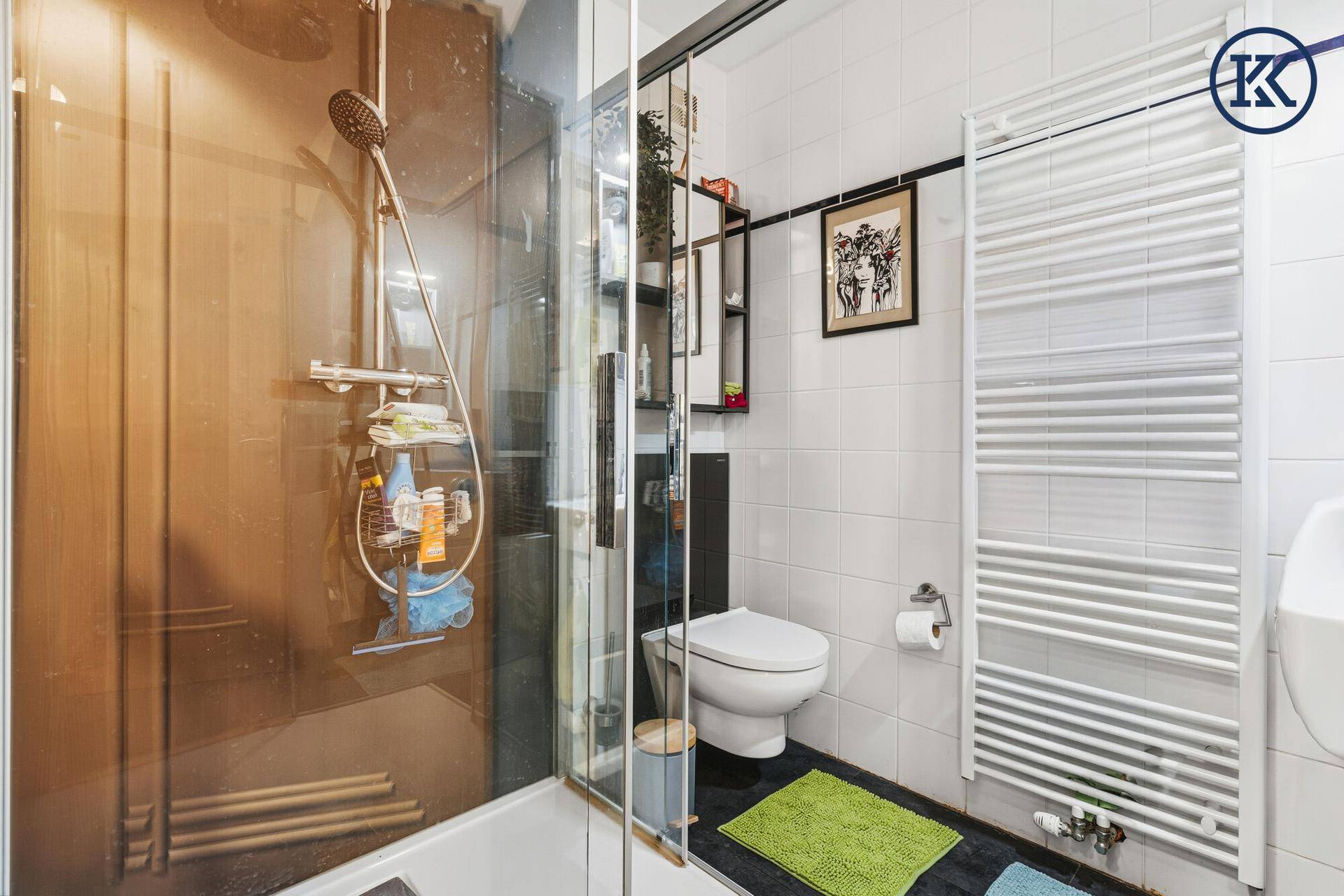 Modernes Badezimmer mit Duschkabine, Wand-WC und beheiztem Handtuchhalter.