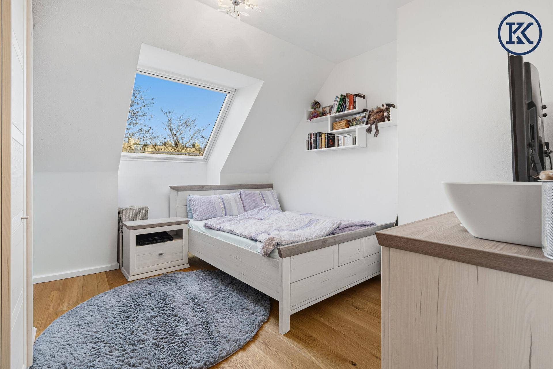 Gemütliches Schlafzimmer im Dachgeschoss mit Dachfenster, Holzboden und Einzelbett.