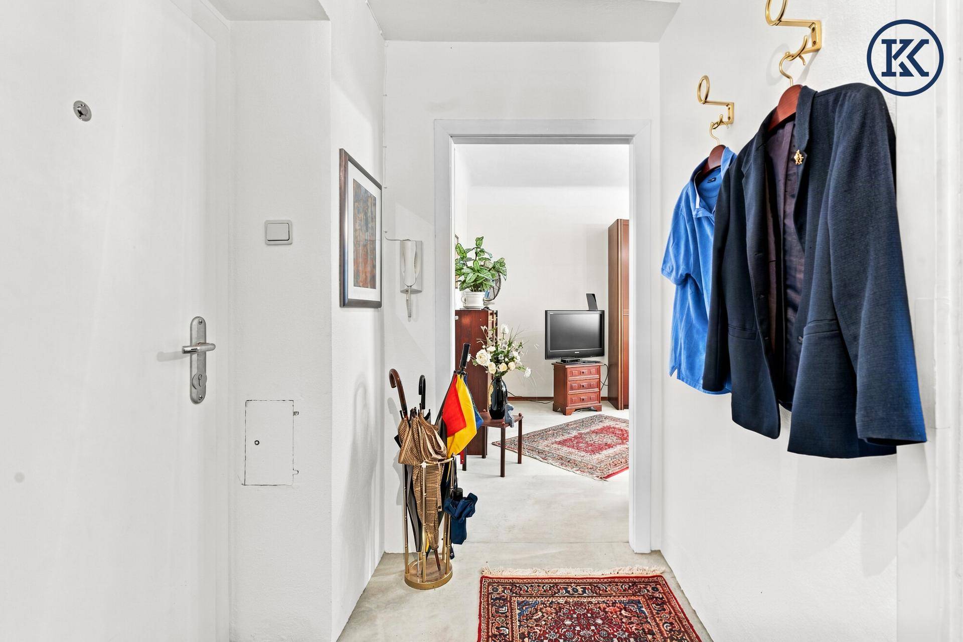 Eingangsbereich mit Garderobe und Blick in das angrenzende Wohnzimmer.