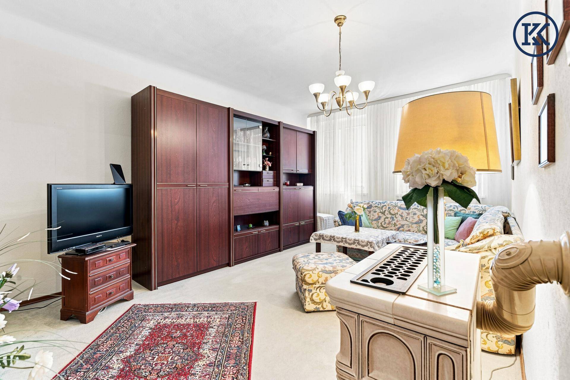 Geräumiges Wohnzimmer mit großer Schrankwand, Teppichboden und gemütlicher Einrichtung.