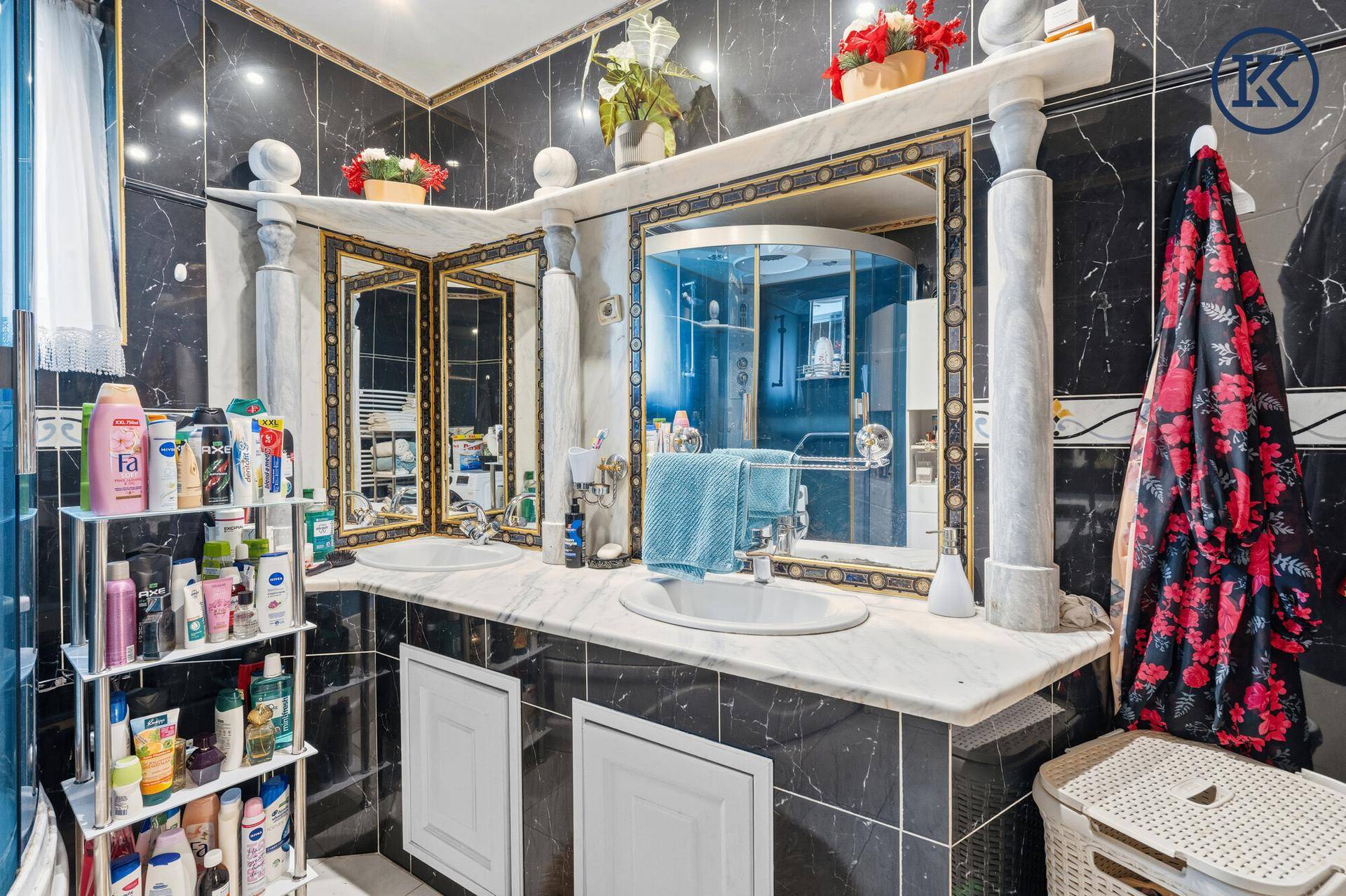 Elegantes Badezimmer mit Doppelwaschbecken, Marmoroberflächen und großer Spiegelfläche.
