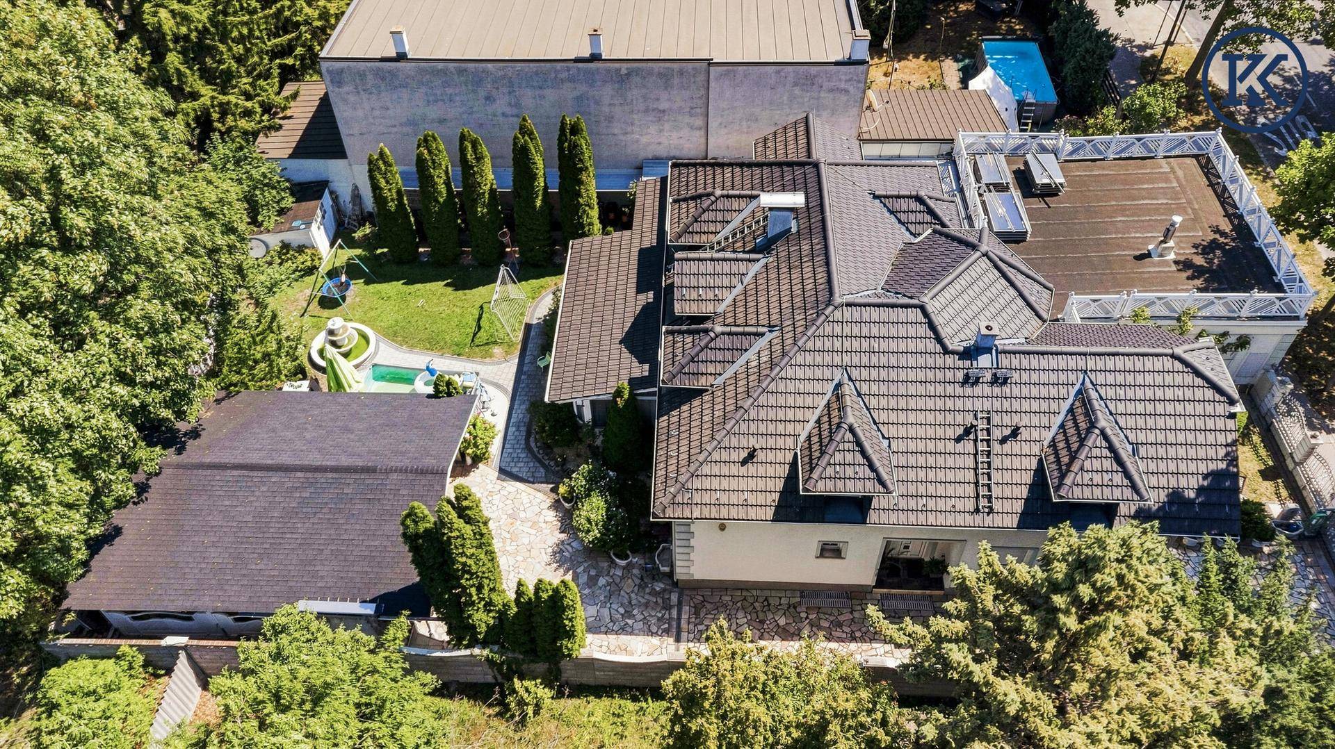 Vogelperspektive des Anwesens mit großem Garten, Pool und Dachterrasse.