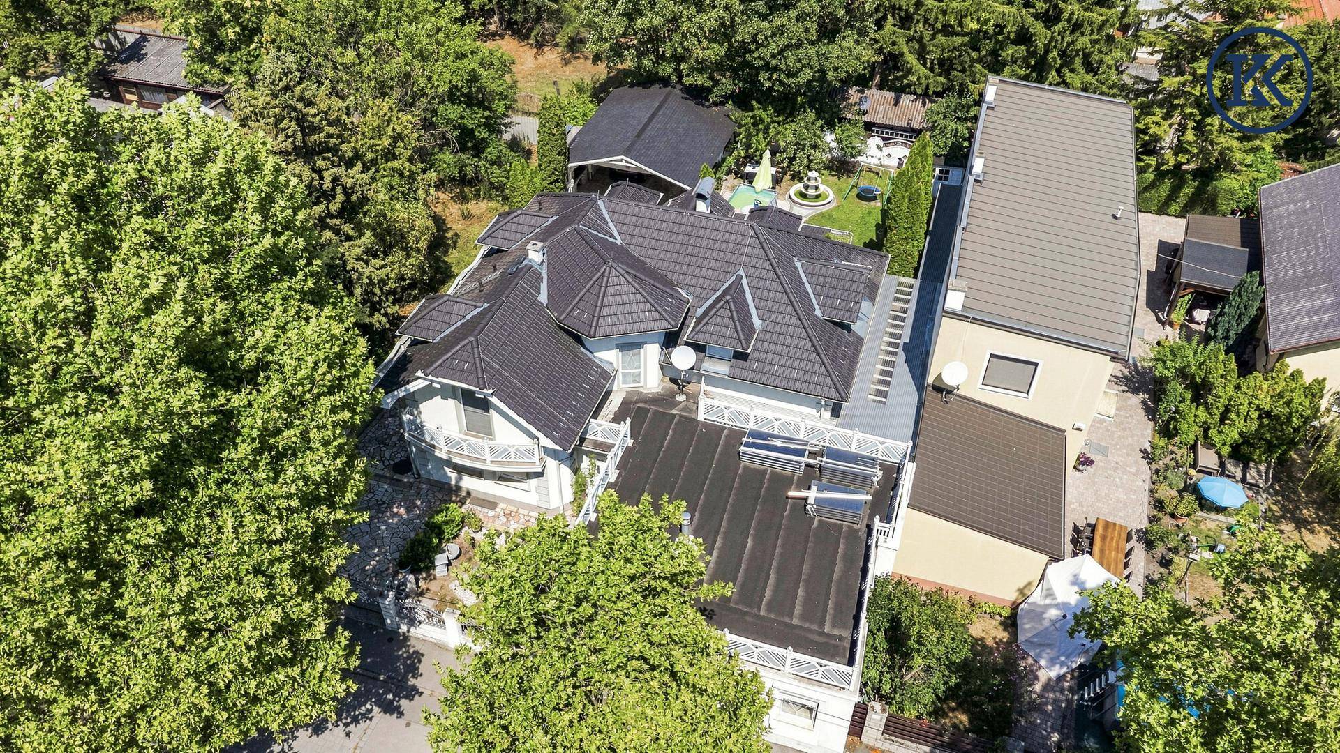 Dachansicht des Hauses mit mehreren Giebeln, umgeben von dichtem Grün.