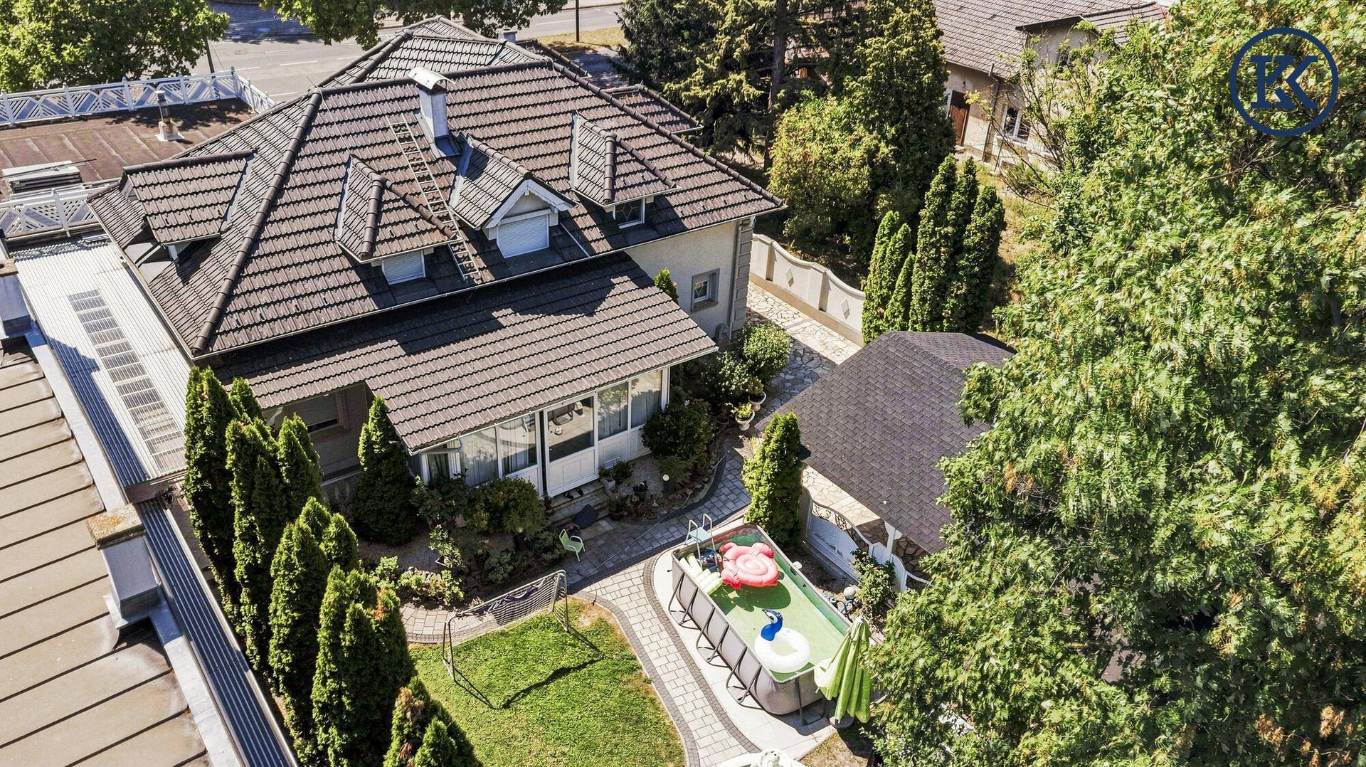 Vogelperspektive des Hauses mit Garten, Poolbereich und umliegender Grünfläche.