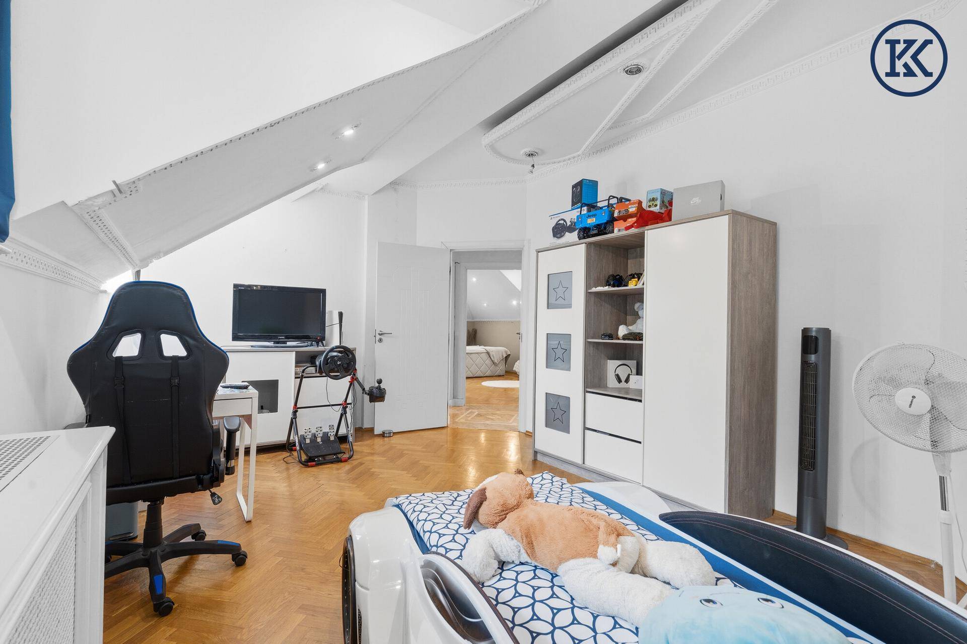 Kinderzimmer mit Spielbereich, Schrank und Blick auf den Flur.