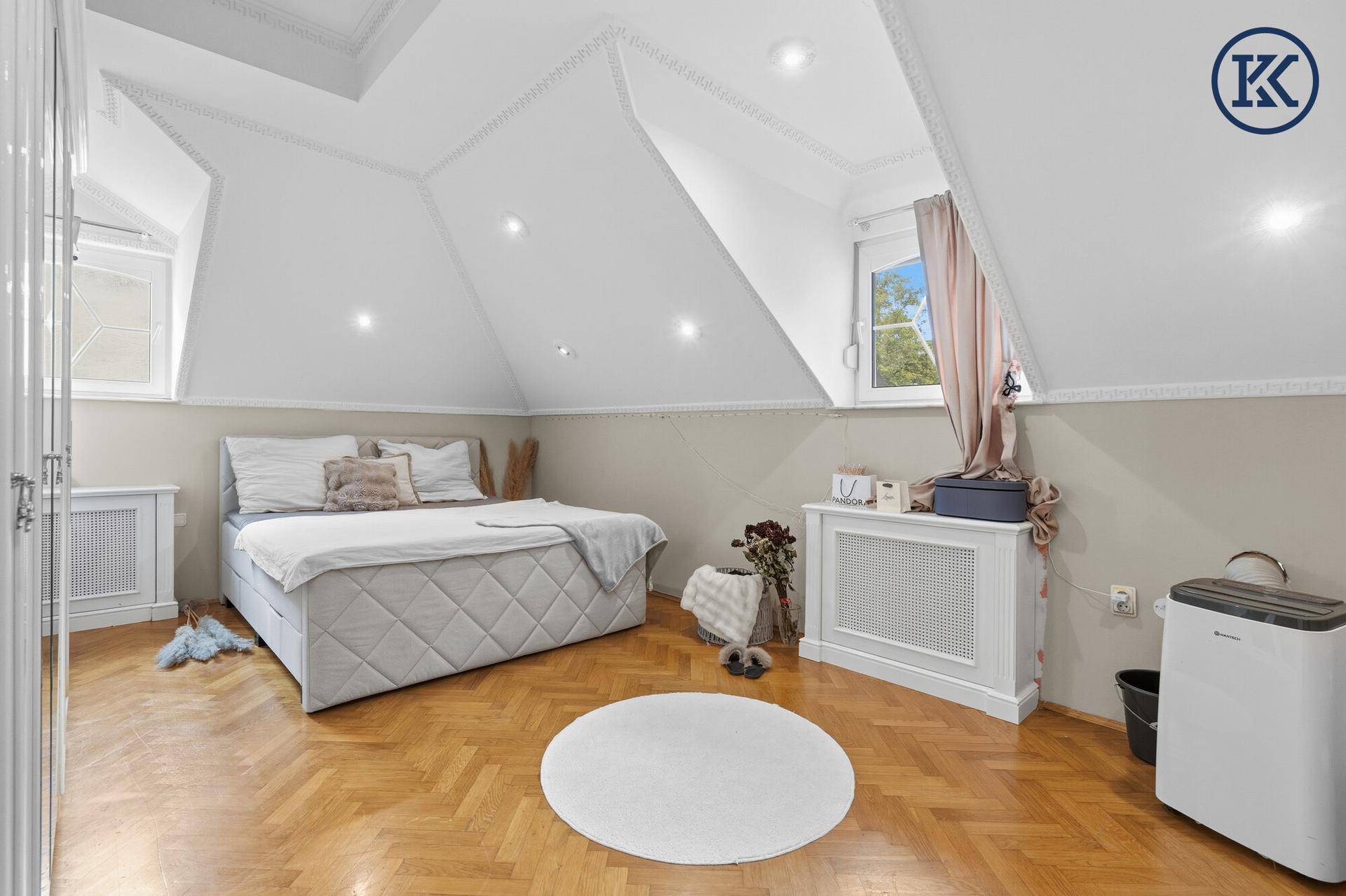 Gemütliches Schlafzimmer im Dachgeschoss mit Doppelbett, Parkettboden und Dachschrägen.