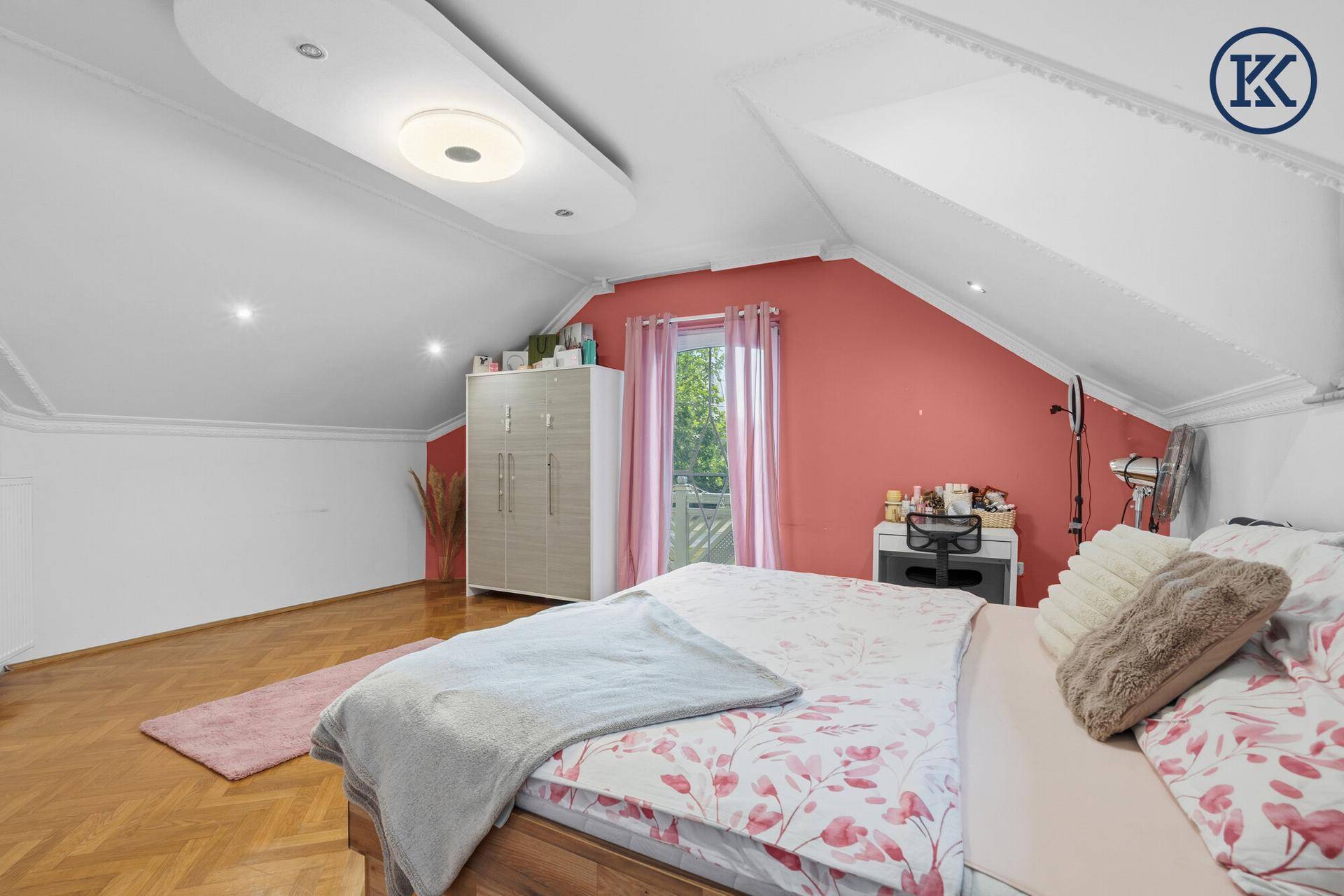 Helles Schlafzimmer im Dachgeschoss mit Balkonzugang, Parkettboden und farbiger Akzentwand.