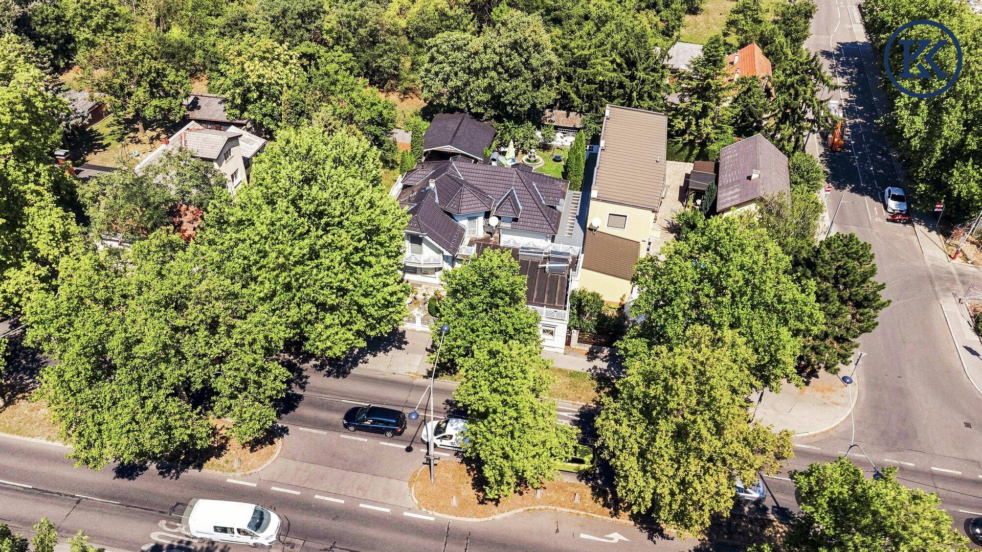 Weitläufige Luftaufnahme des Anwesens im Kontext der Nachbarschaft und der angrenzenden Straße.
