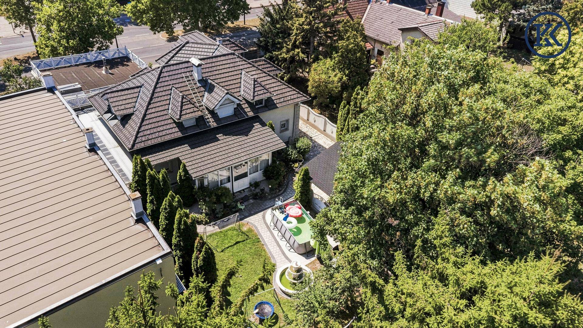Vogelperspektive des Hauses mit großem Garten, Springbrunnen und einem Spielbereich für Kinder.