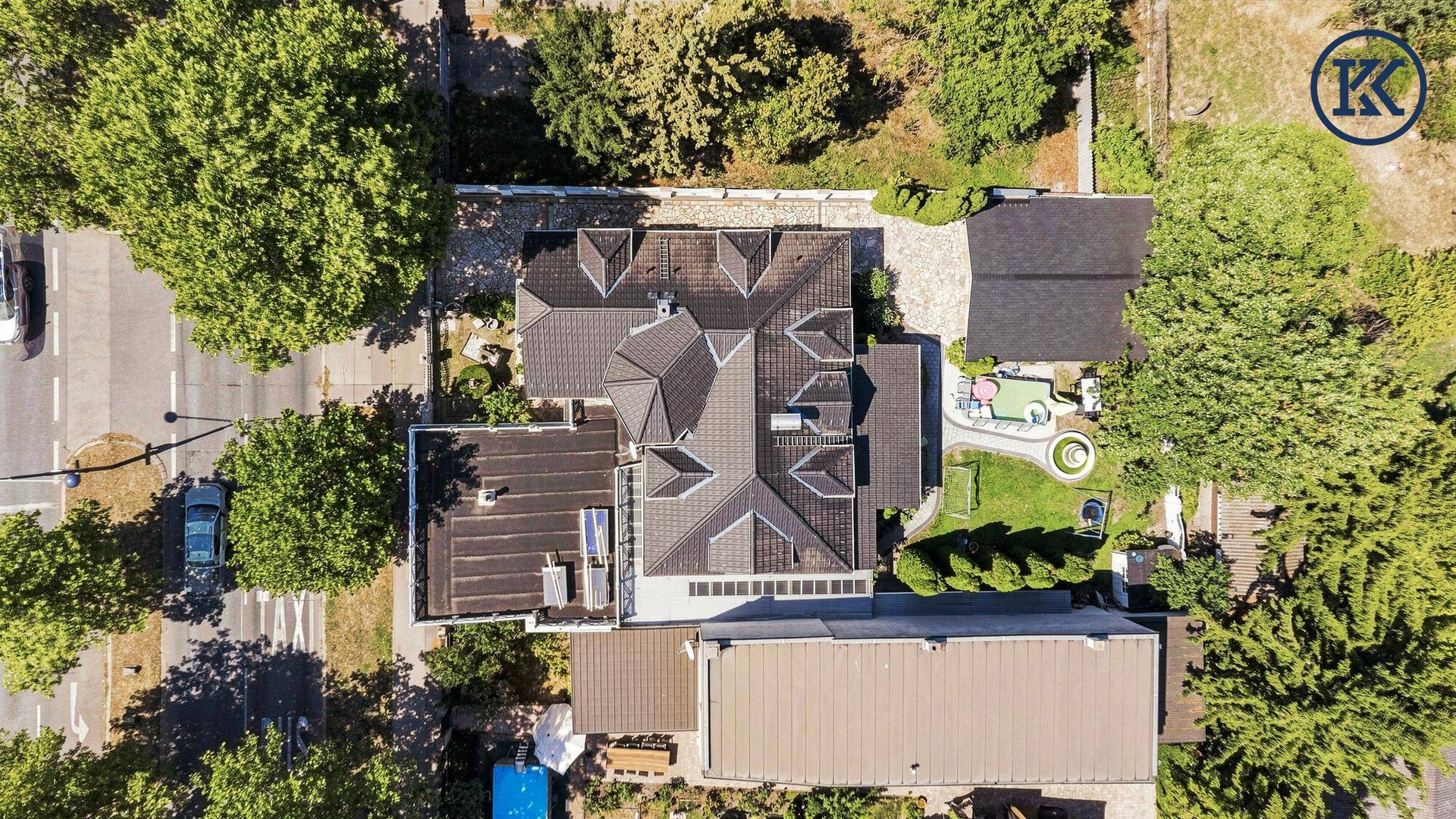 Draufsicht des Grundstücks mit Haus, Garten, Pool und Zufahrt.