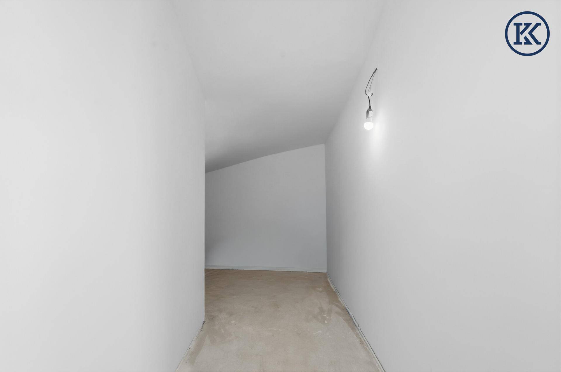 Schmaler, heller Flur im Obergeschoss mit schräger Decke, noch im Rohbauzustand.