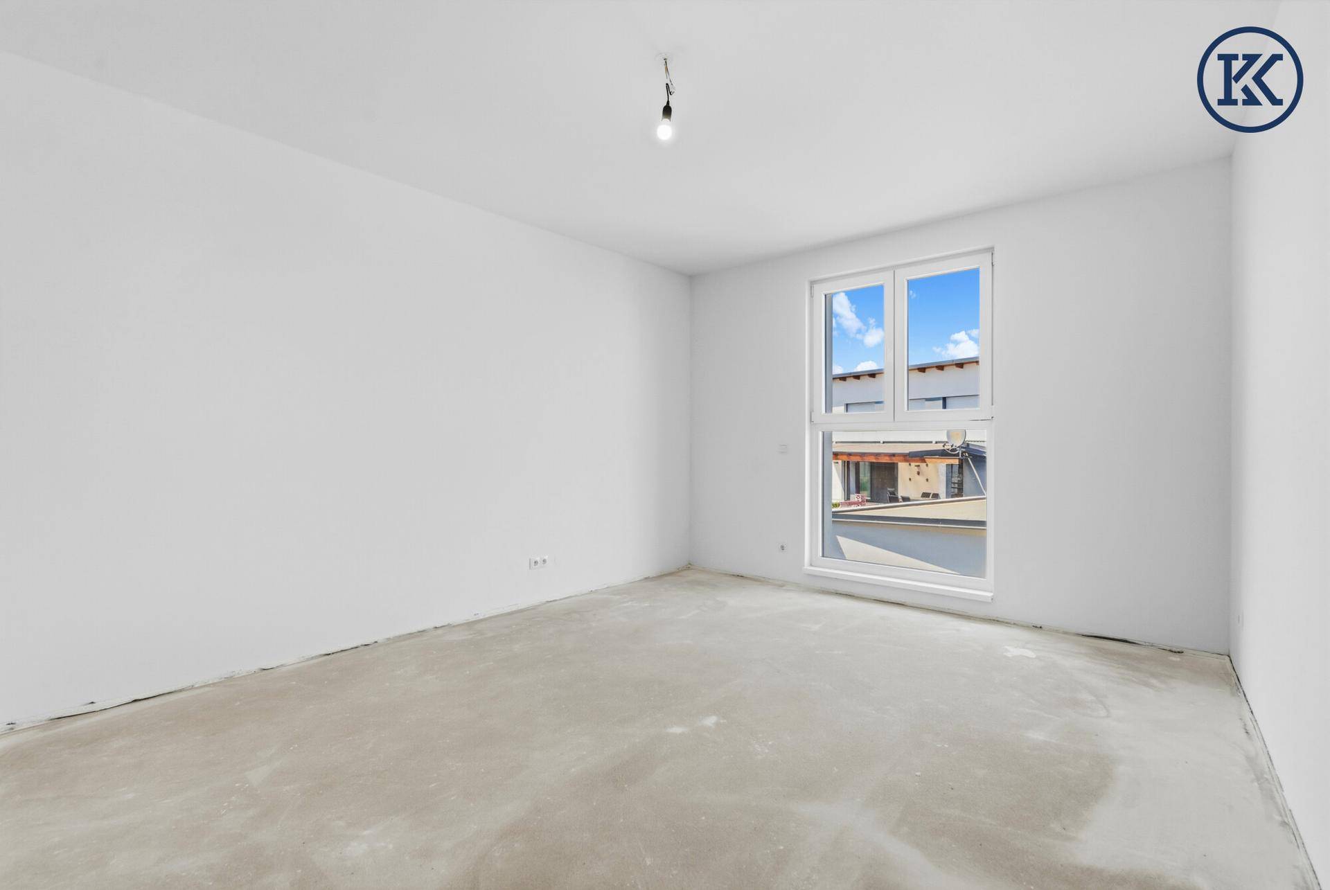 Helles Schlafzimmer im Obergeschoss mit großem Fenster und Blick auf die Umgebung.
