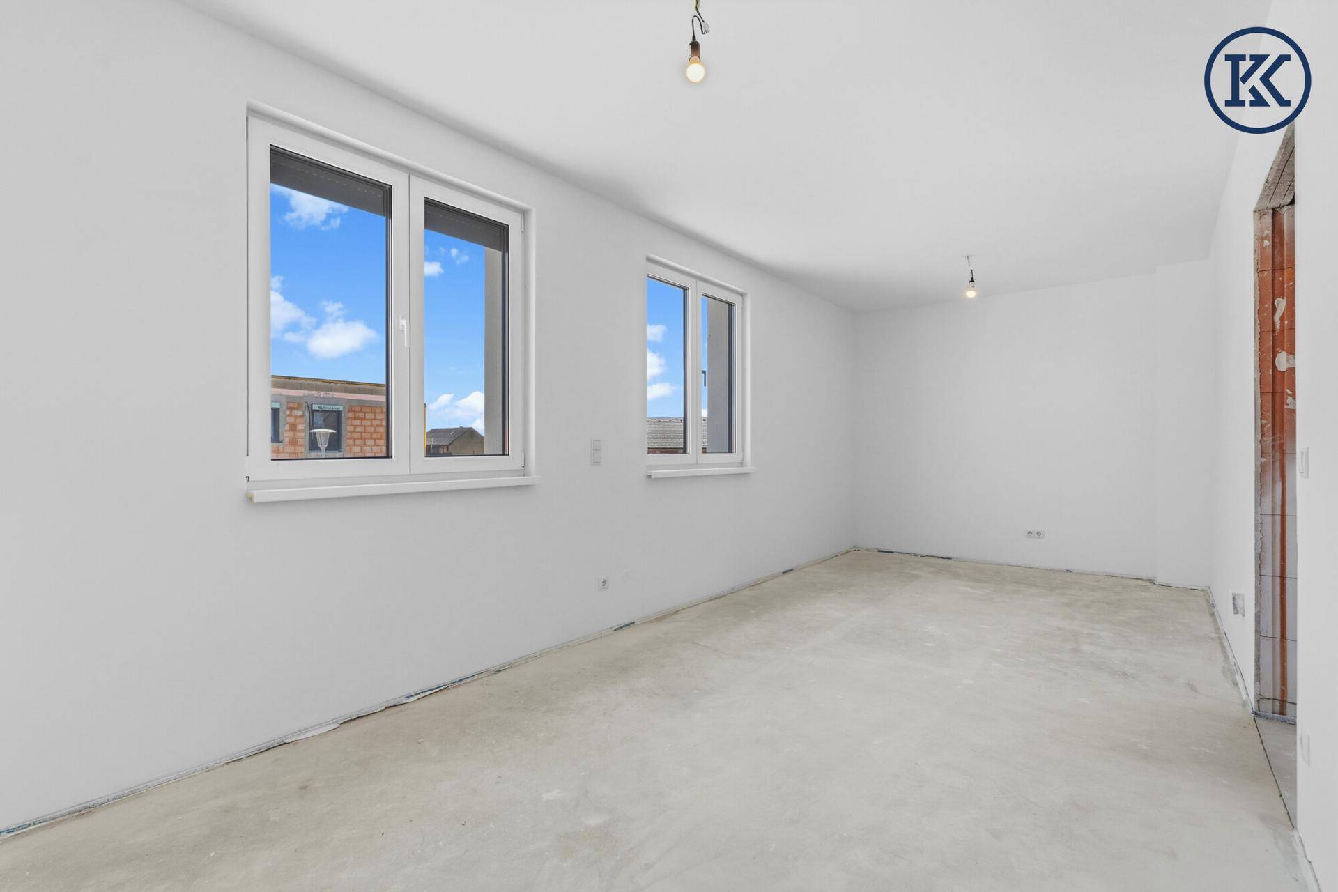 Geräumiges Zimmer im Obergeschoss mit viel Tageslicht durch zwei große Fenster.