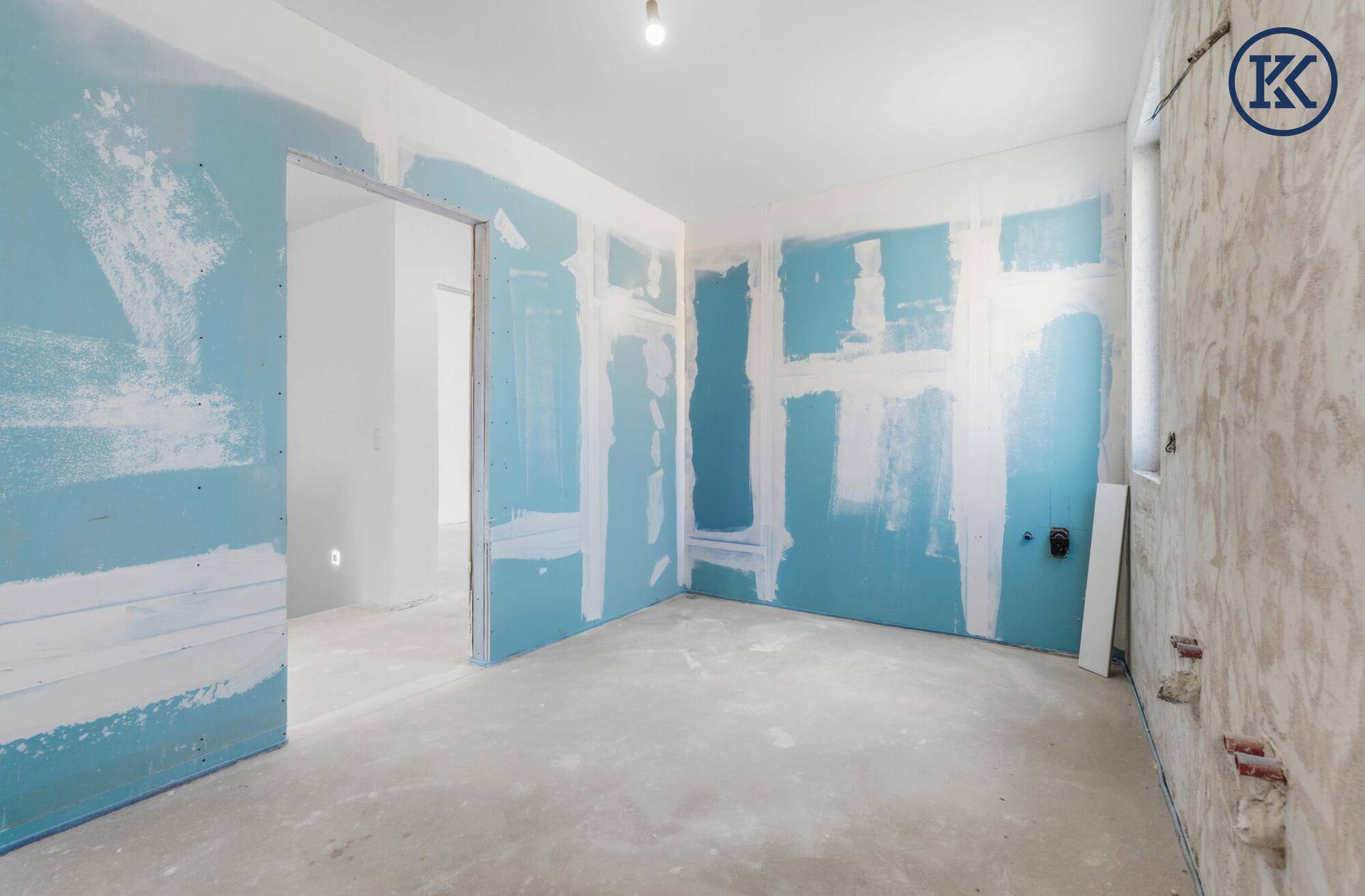 Rohbau-Badezimmer mit blauen Trockenbauwänden und Anschlüssen für Sanitärinstallationen.