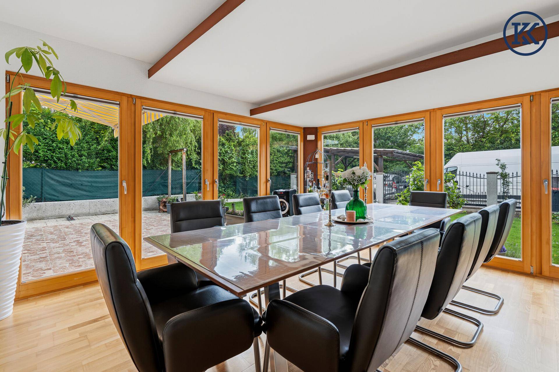 Lichtdurchfluteter Essbereich mit Holzboden, großem Esstisch und Blick in den Garten.