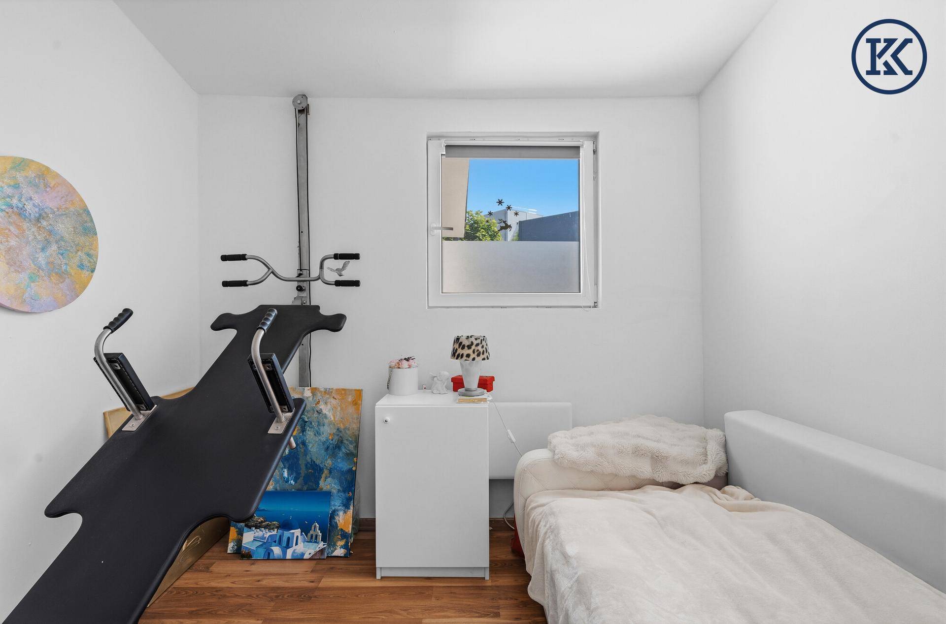 Weiterer Blick ins Schlafzimmer mit Einzelbett und Trainingsgerät, hell und funktional.