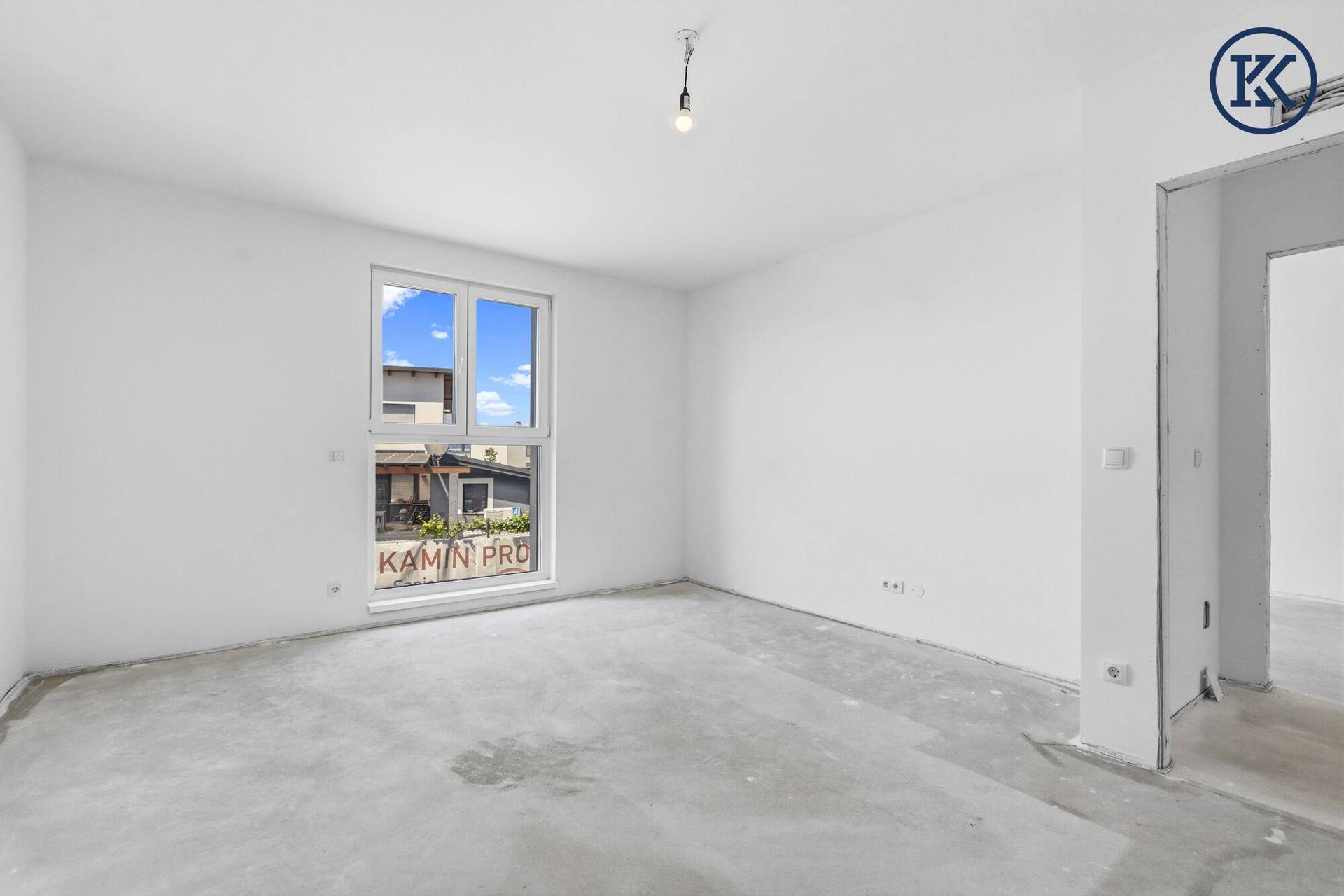 Helles Zimmer im Rohbau mit großem Fenster und viel Potenzial für individuelle Gestaltung.