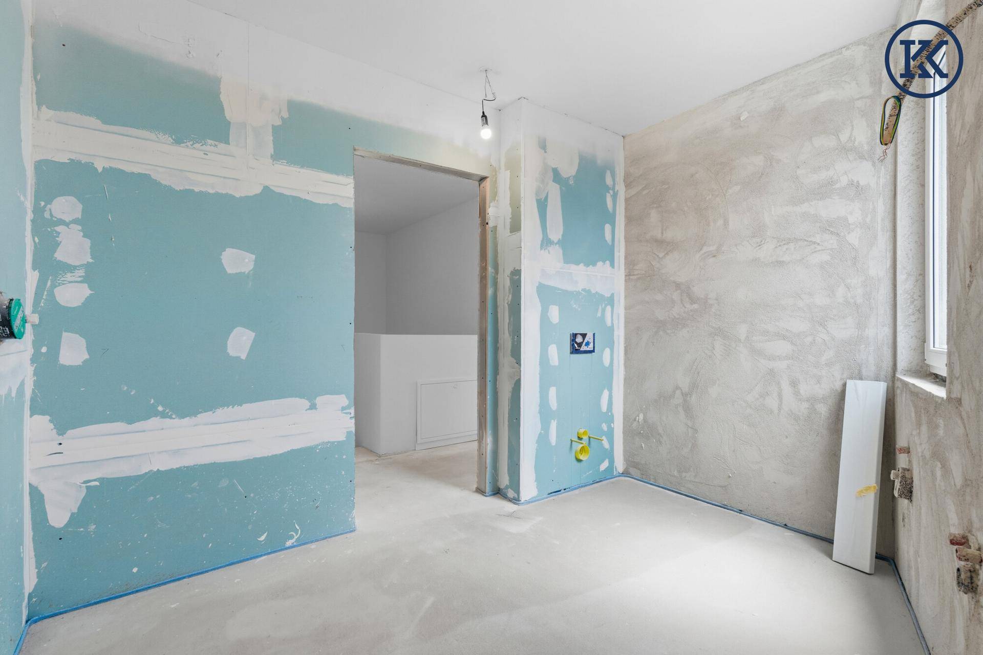 Rohbau-Badezimmer mit Trockenbauwänden und Blick in den angrenzenden Raum, bereit für Ausbau.