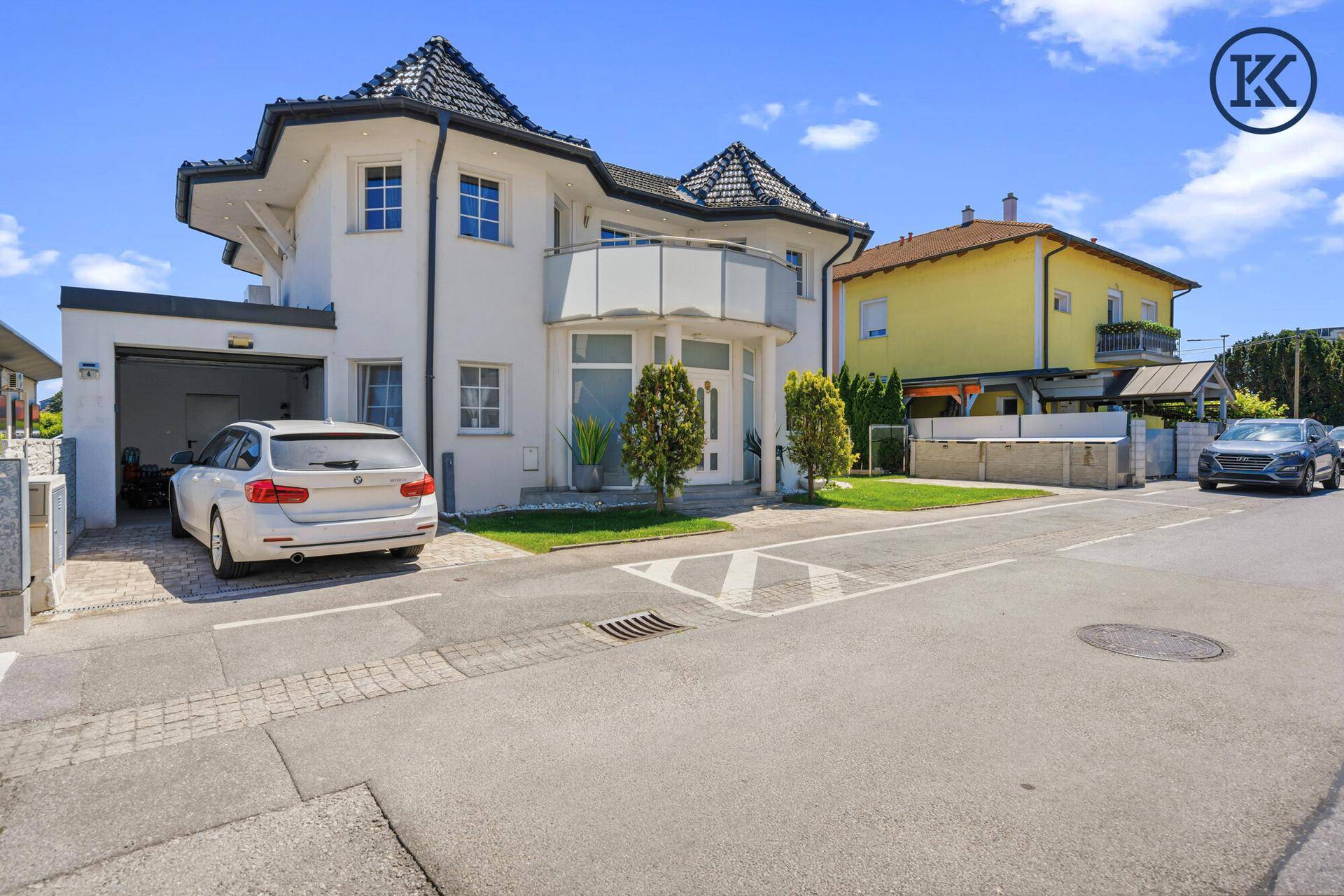 Moderne Villa mit Garage und gepflegter Auffahrt, umgeben von einer ruhigen Wohngegend.