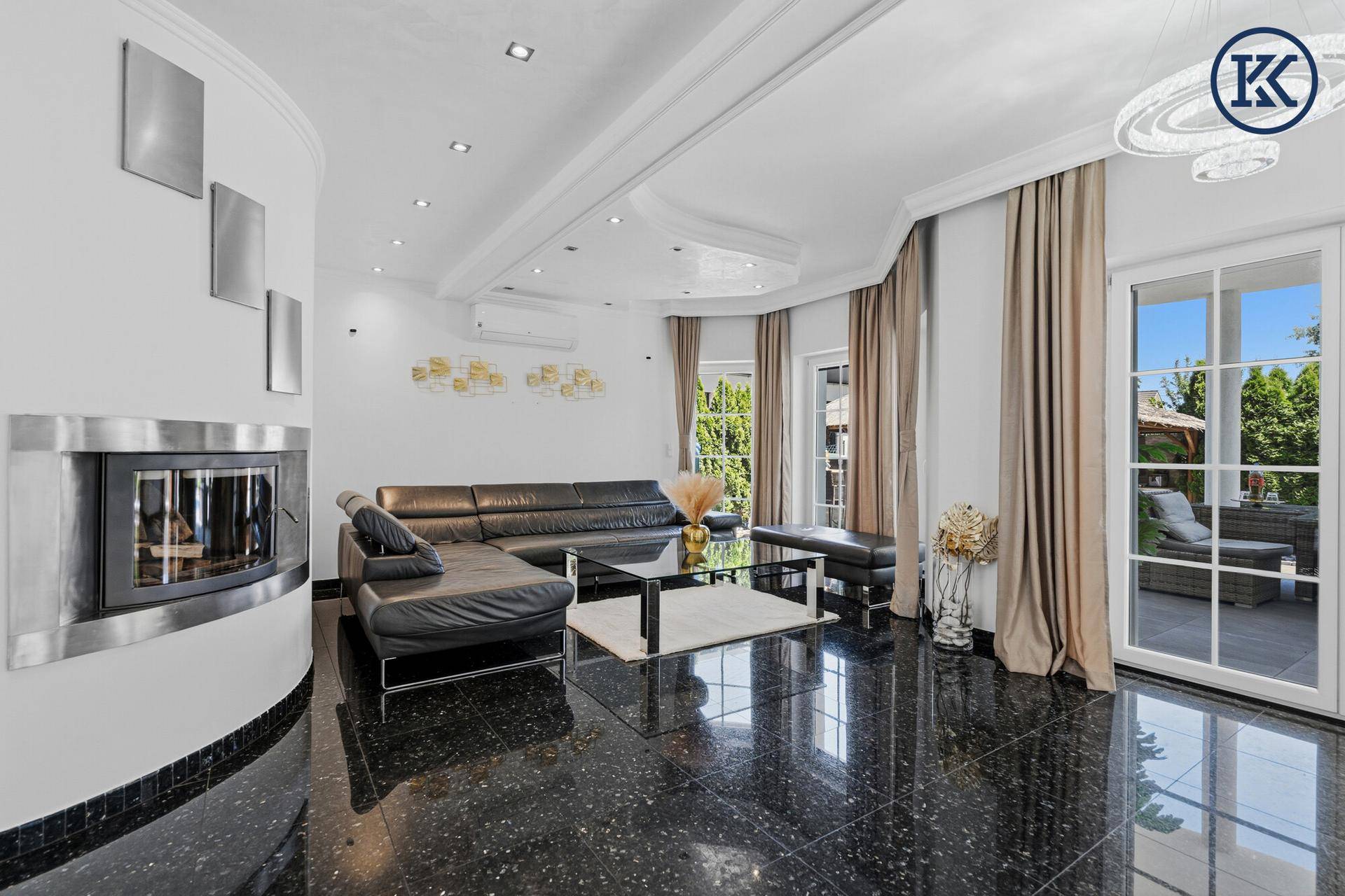 Elegantes Wohnzimmer mit Kamin, dunklem Marmorboden und Zugang zur Terrasse.
