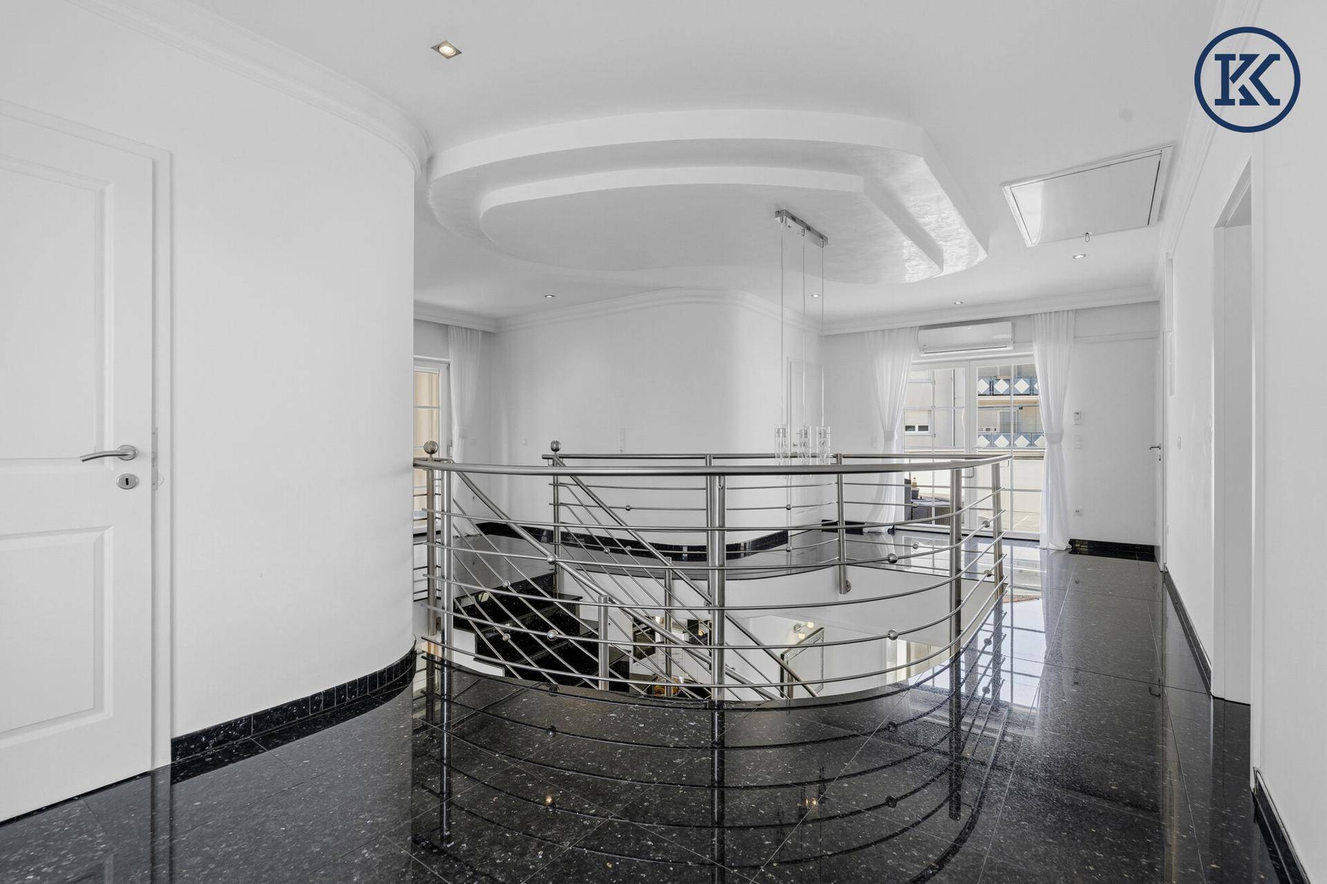 Geräumiger Flur im Obergeschoss mit eleganter Treppengalerie und stilvoller Deckenform.