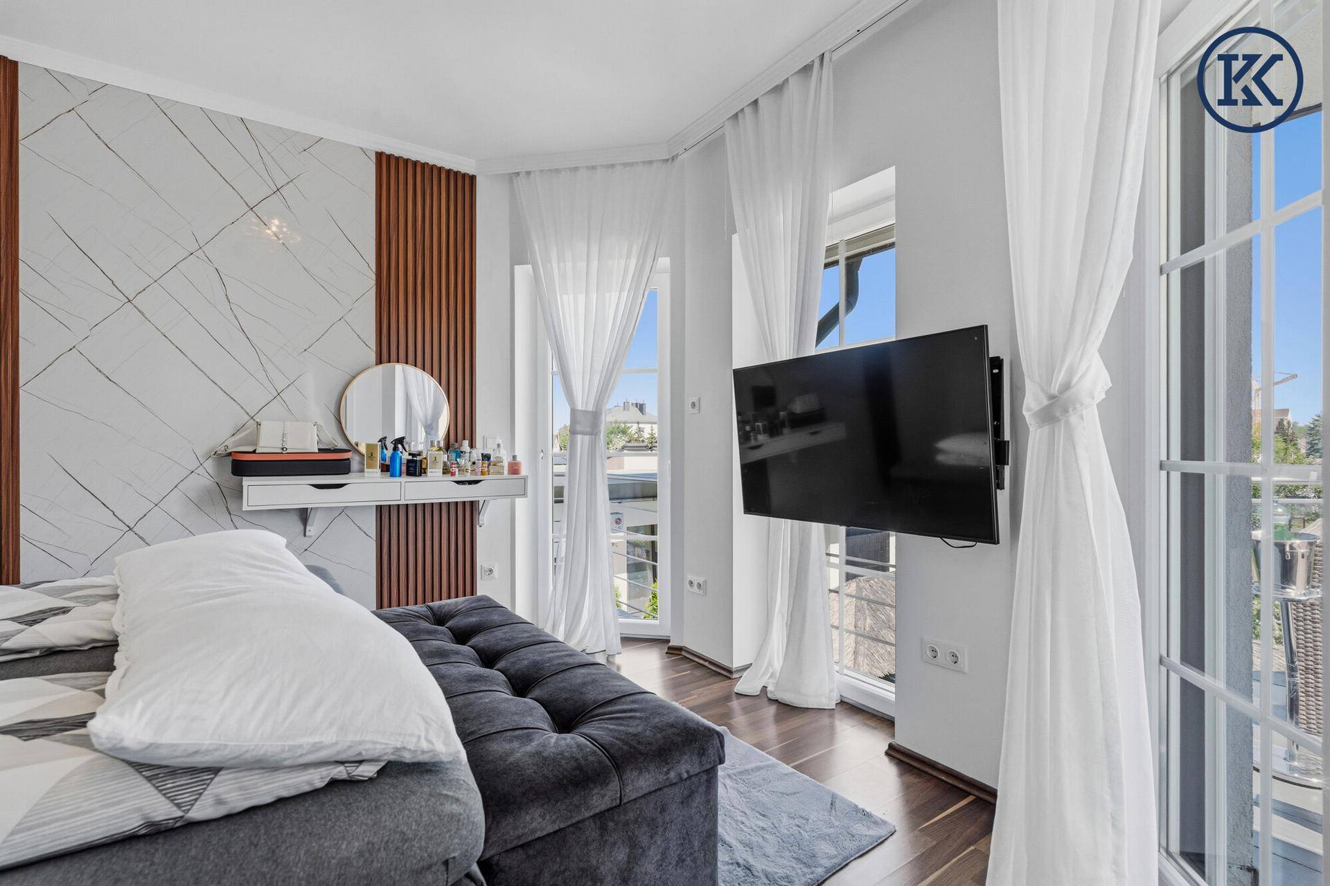 Helles Schlafzimmer mit Zugang zu einem Balkon und moderner Einrichtung, die viel Licht bietet.