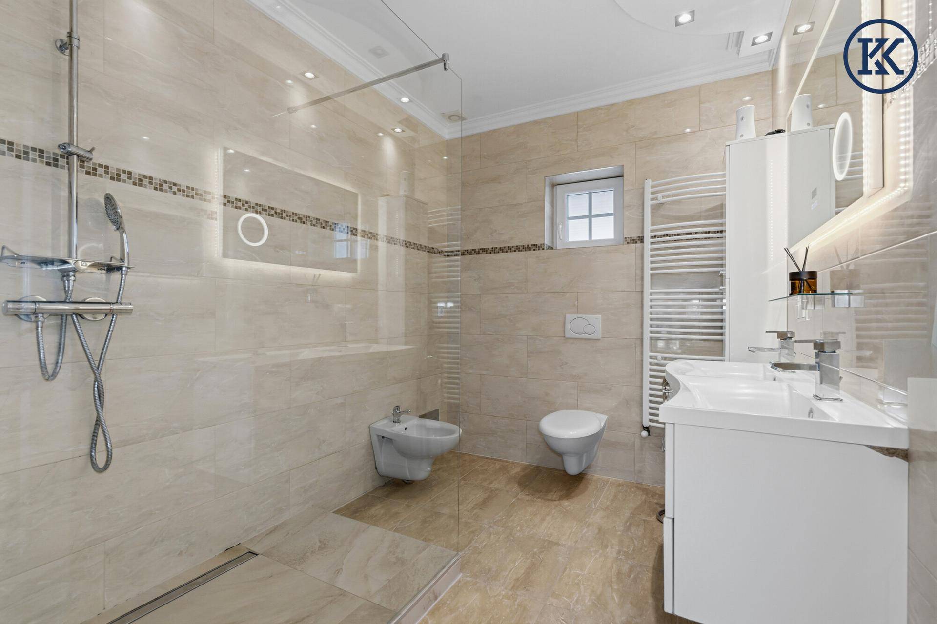 Modernes Badezimmer mit begehbarer Dusche, Bidet, Doppelwaschbecken und beheiztem Handtuchhalter.
