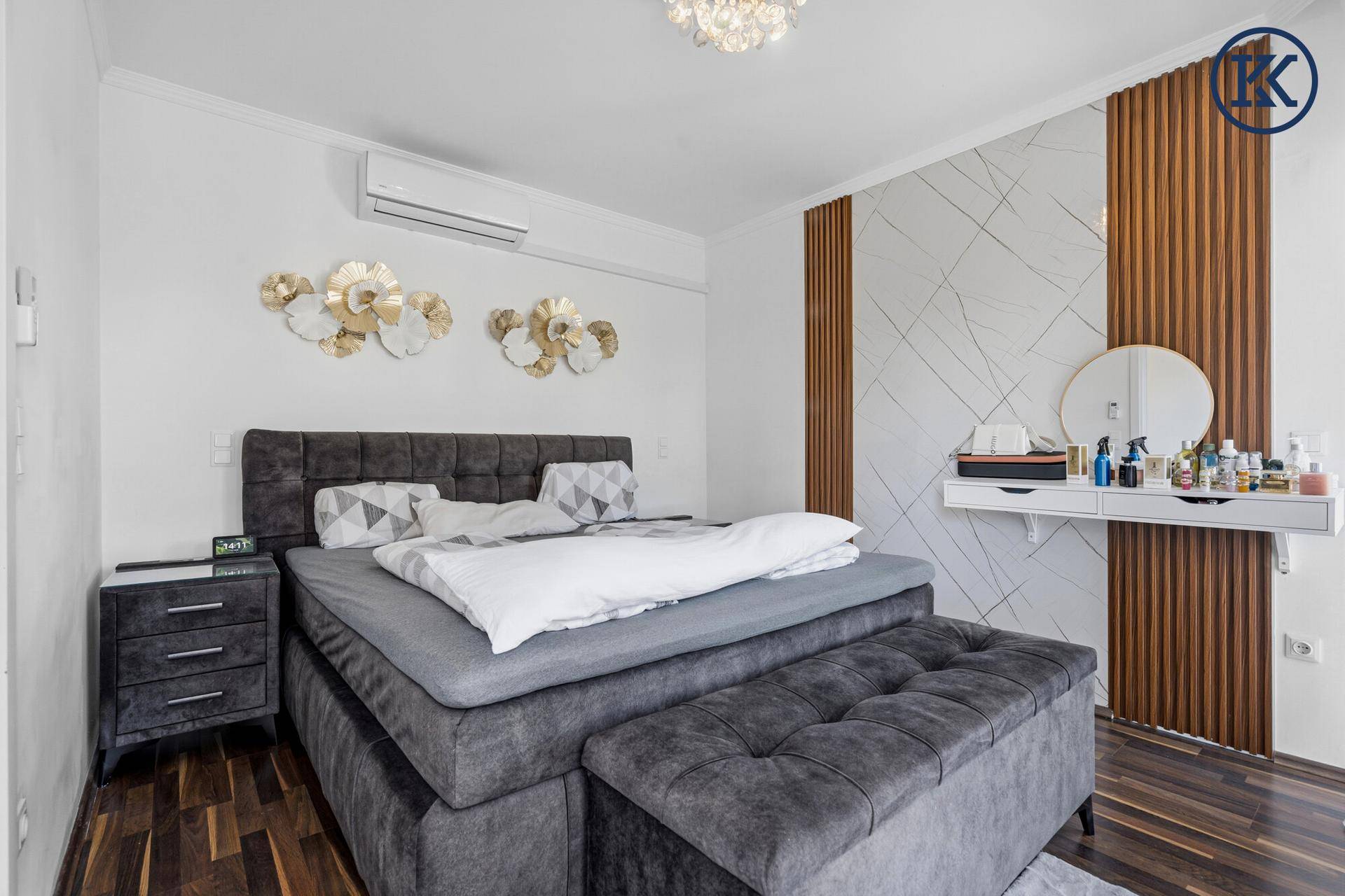 Modernes Schlafzimmer mit großem Bett, Klimaanlage und dekorativer Wandgestaltung aus Holzpaneelen.