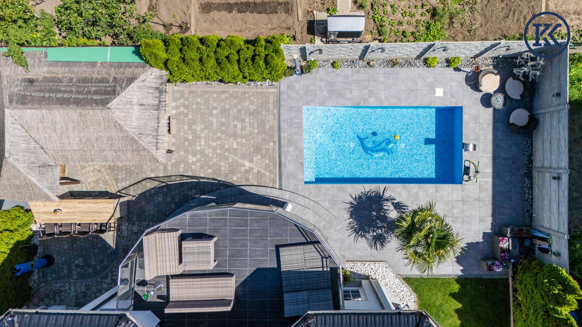 Draufsicht auf das Anwesen mit großem Pool, Terrasse, Gartenbereich und Außenküche.