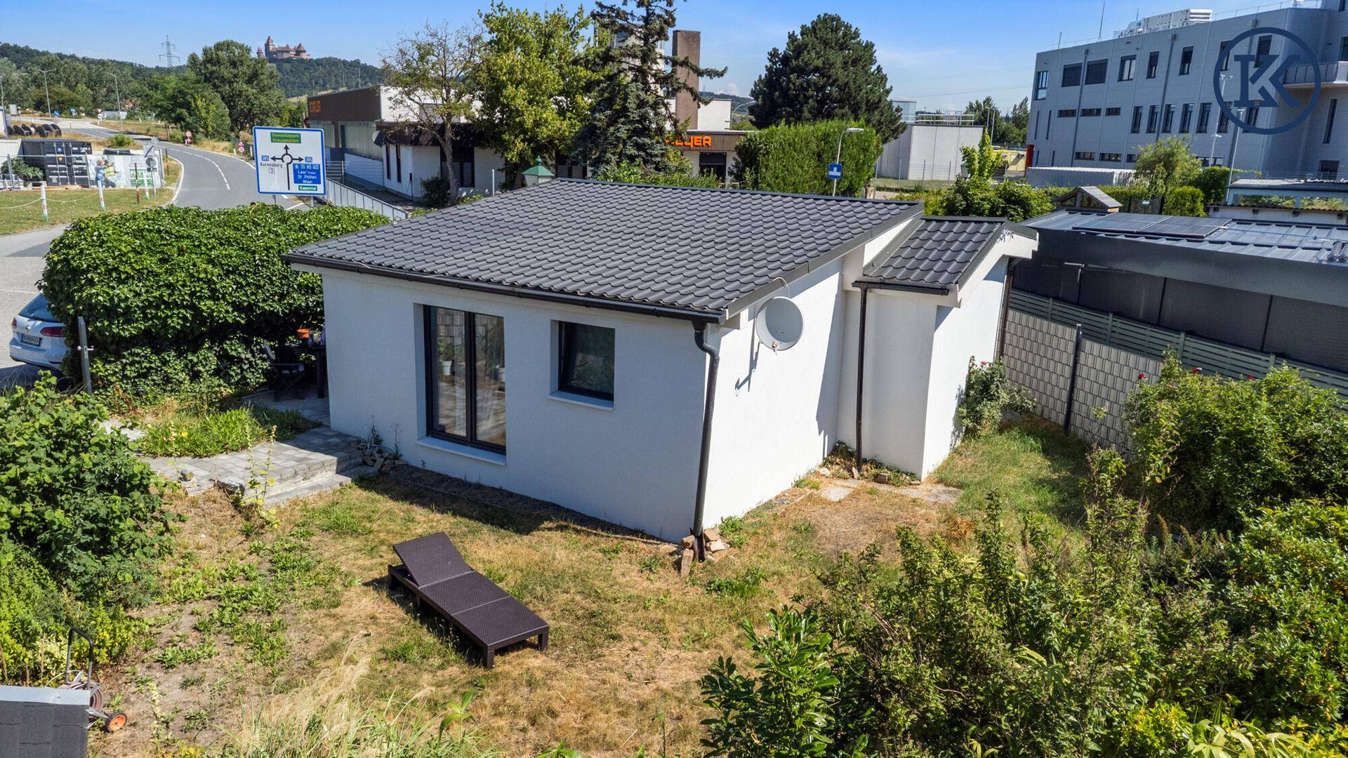 Vogelperspektive des Hauses mit Garten, umgeben von einer Straße und weiteren Gebäuden.