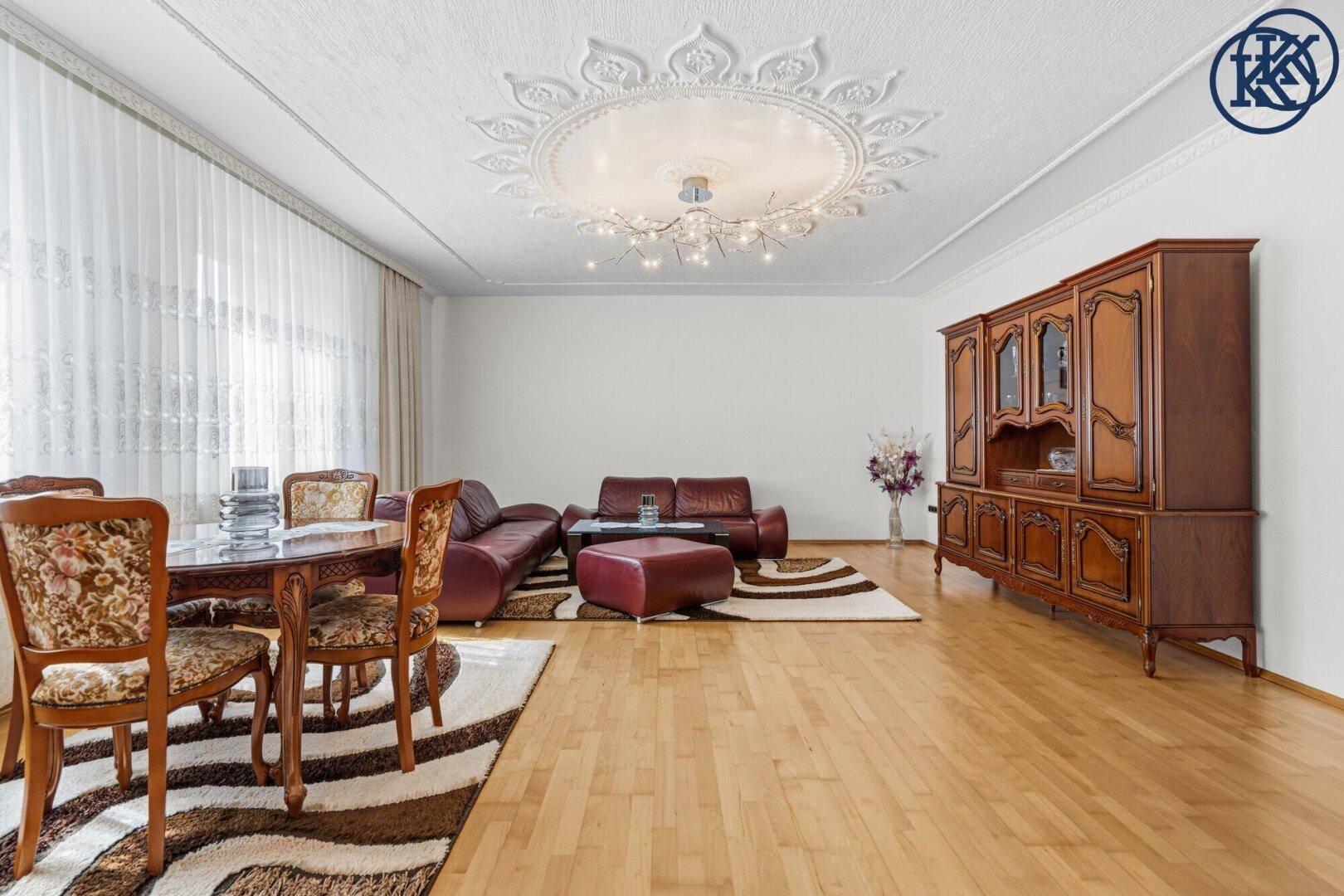 Geräumiger Wohn-Essbereich mit Holztisch, klassischen Möbeln und Parkettboden.
