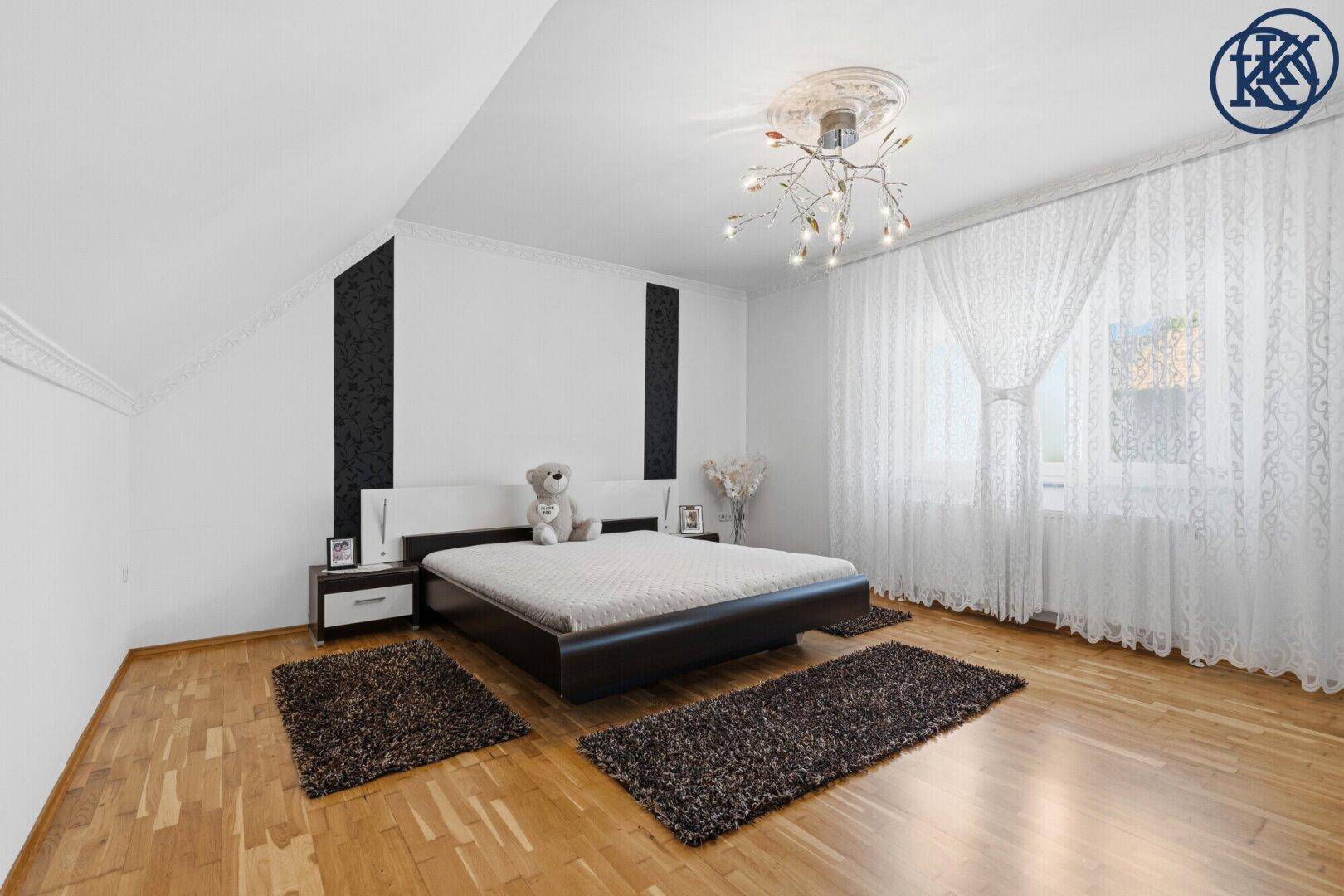 Helles Schlafzimmer mit Parkettboden, modernem Bett und dekorativen Akzenten an den Wänden.