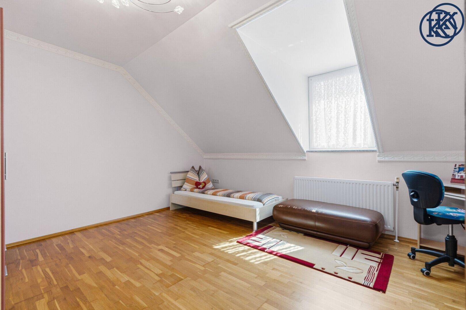 Kinderzimmer mit Parkettboden, Einzelbett und Dachfenster, ideal für junge Bewohner.