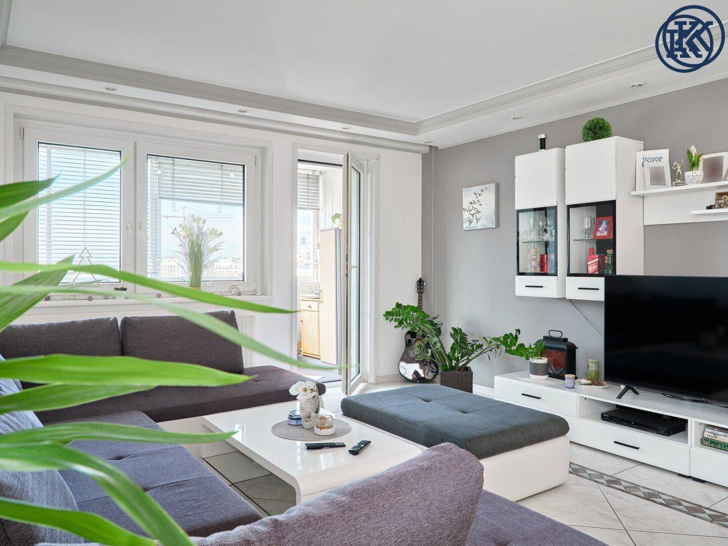 Gemütlicher Wohnbereich mit Sofa, Couchtisch und Blick auf den Balkon.