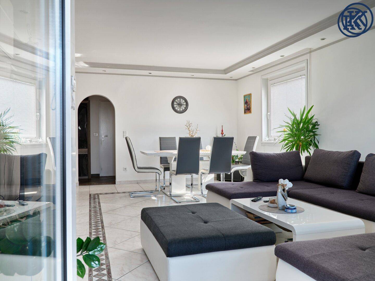 Wohn- und Essbereich mit Sofa, Couchtisch und Esstisch, gut beleuchtet.