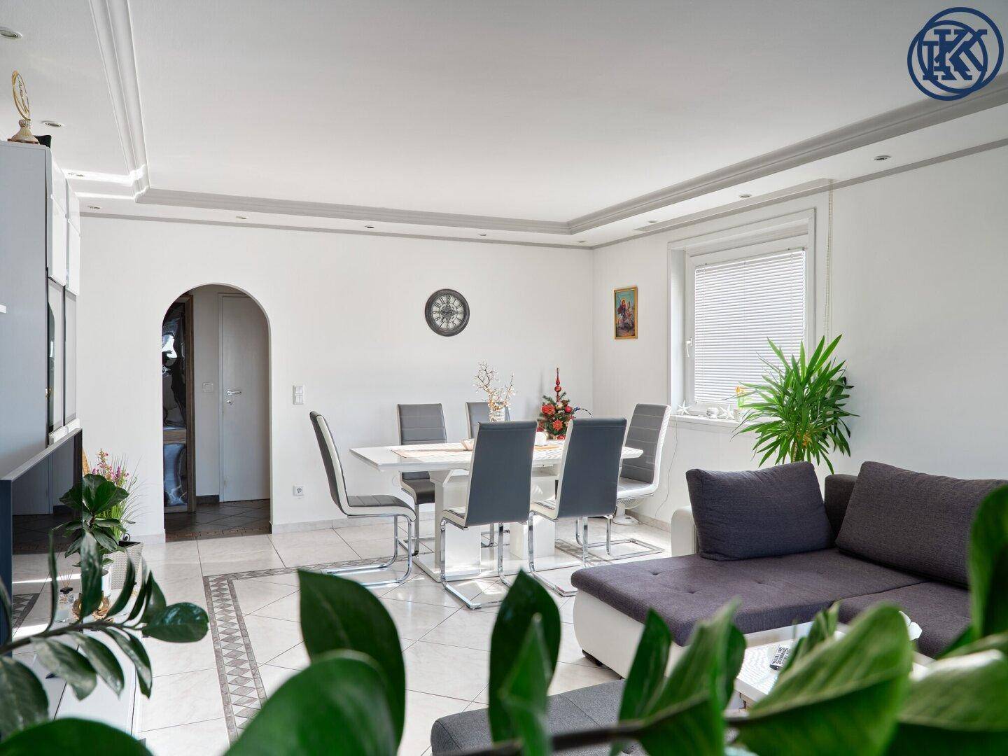Geräumiger Wohn- und Essbereich mit Sofa, Esstisch und viel Tageslicht.