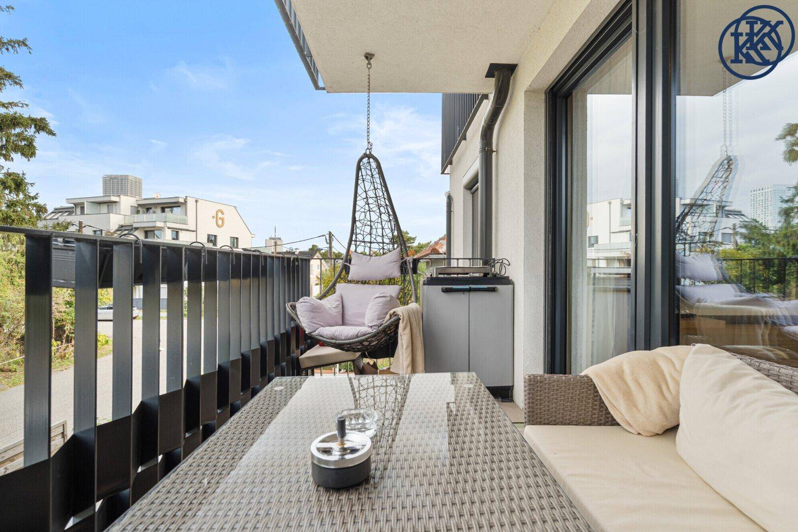 Gemütlicher Balkon mit modernen Gartenmöbeln und einem entspannenden Hängesessel.