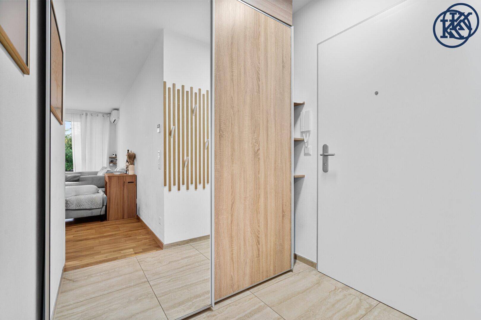 Heller Eingangsbereich mit modernen Fliesen, Spiegelschrank und Holzelementen.