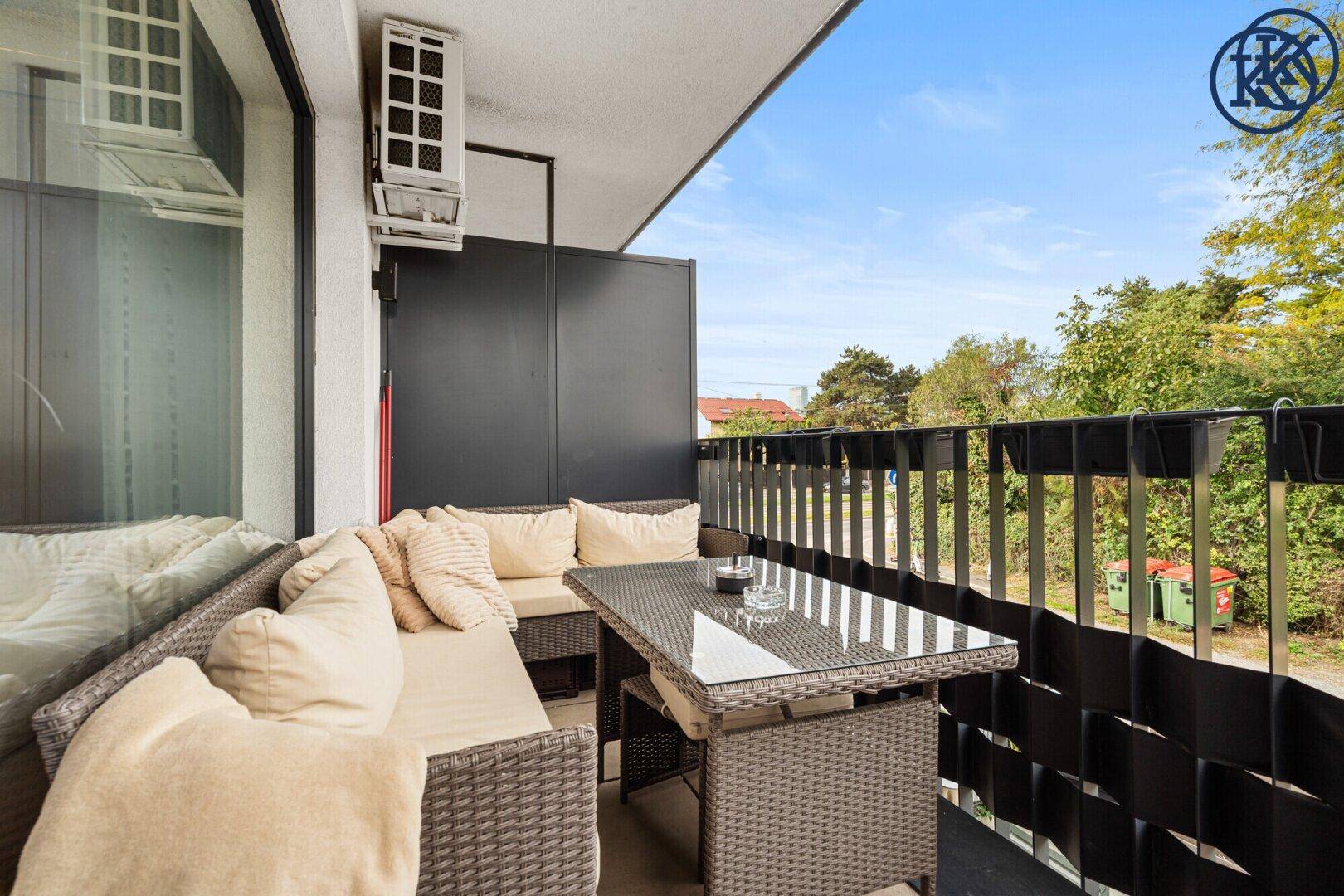 Geräumiger Balkon mit bequemen Outdoor-Möbeln und Blick ins Grüne.
