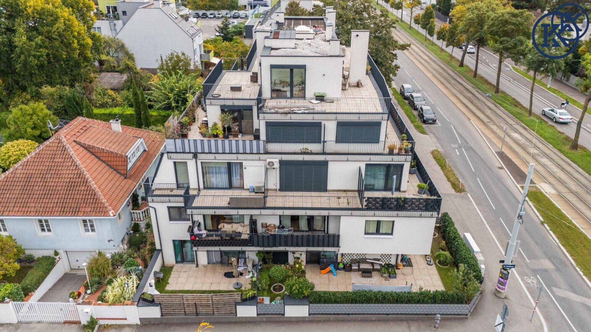 Übersichtliche Luftaufnahme des modernen Wohnkomplexes mit Terrassen und angrenzender Straße.