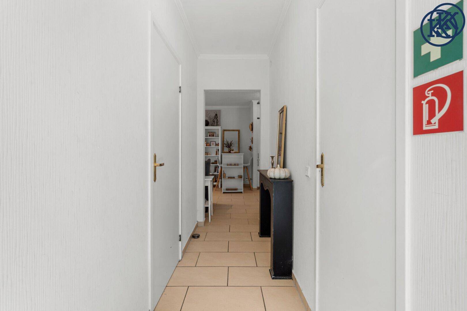 Heller Flur mit Fliesenboden und Zugang zu weiteren Räumen, minimalistisch gestaltet.