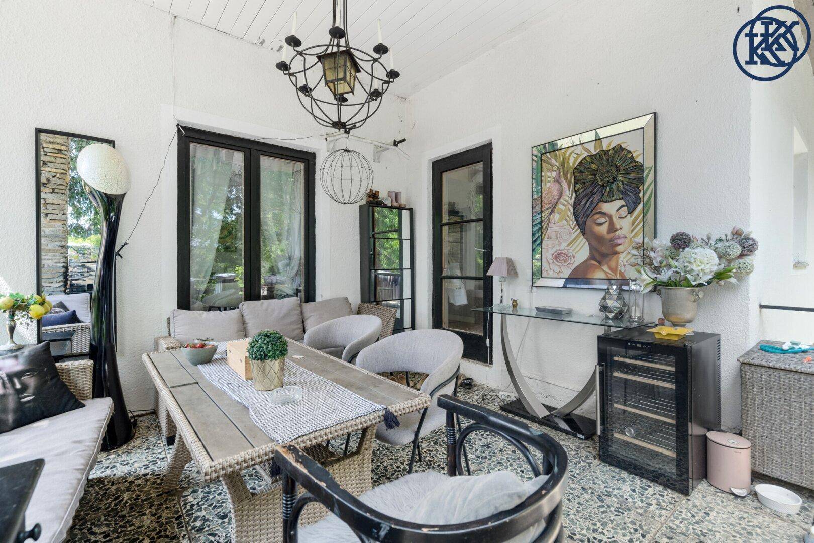 Geräumige überdachte Terrasse mit Essbereich und Lounge-Möbeln, ideal für gesellige Zusammenkünfte.