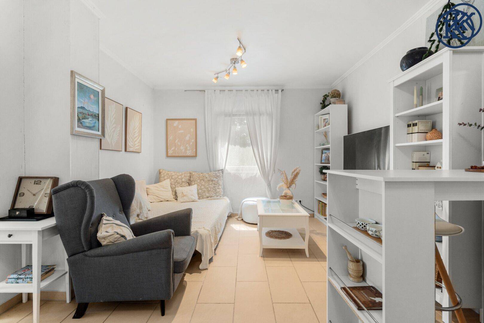 Heller Wohnraum mit Schlafsofa, Regalen und einem kleinen Bartresen, ideal für Gäste.