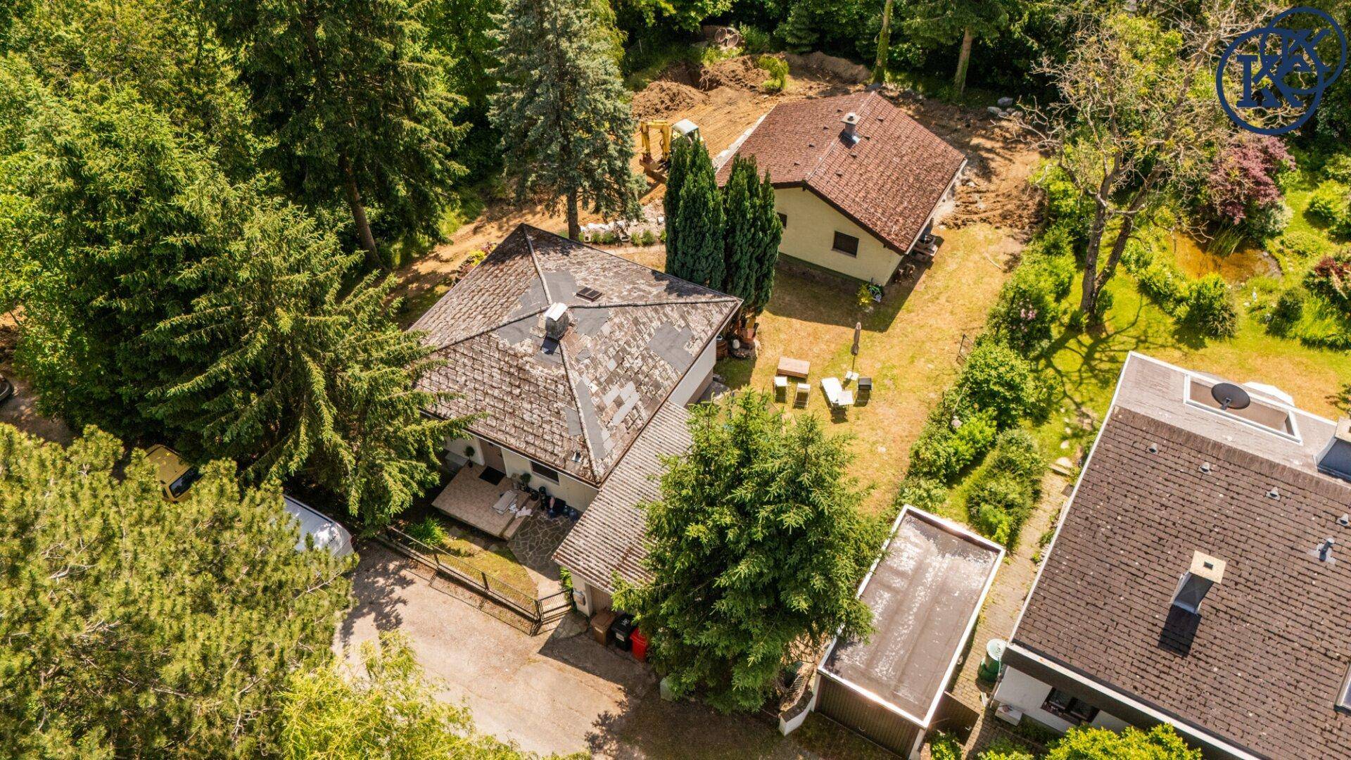Weitläufige Luftaufnahme des Anwesens mit mehreren Gebäuden und viel Baumbestand in der Umgebung.